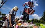 Christine Feldmann pauses after laying down flowers at the makeshift memorial outside the Capital Gazette newsroom in Annapolis, Md., on Friday, June 