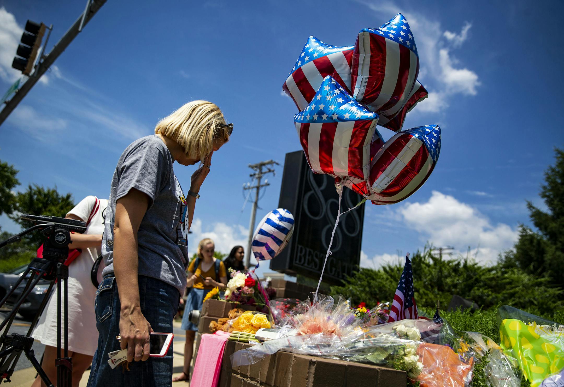 Christine Feldmann pauses after laying down flowers at the makeshift memorial outside the Capital Gazette newsroom in Annapolis, Md., on Friday, June 29, 2018. Jarrod Ramos, who had a grudge against the newspaper, barricaded the backdoor to prevent people from fleeing as he used a pump-action shotgun on Thursday to shoot his way into the newsroom, the authorities said Friday. (Al Drago/The New York Times)