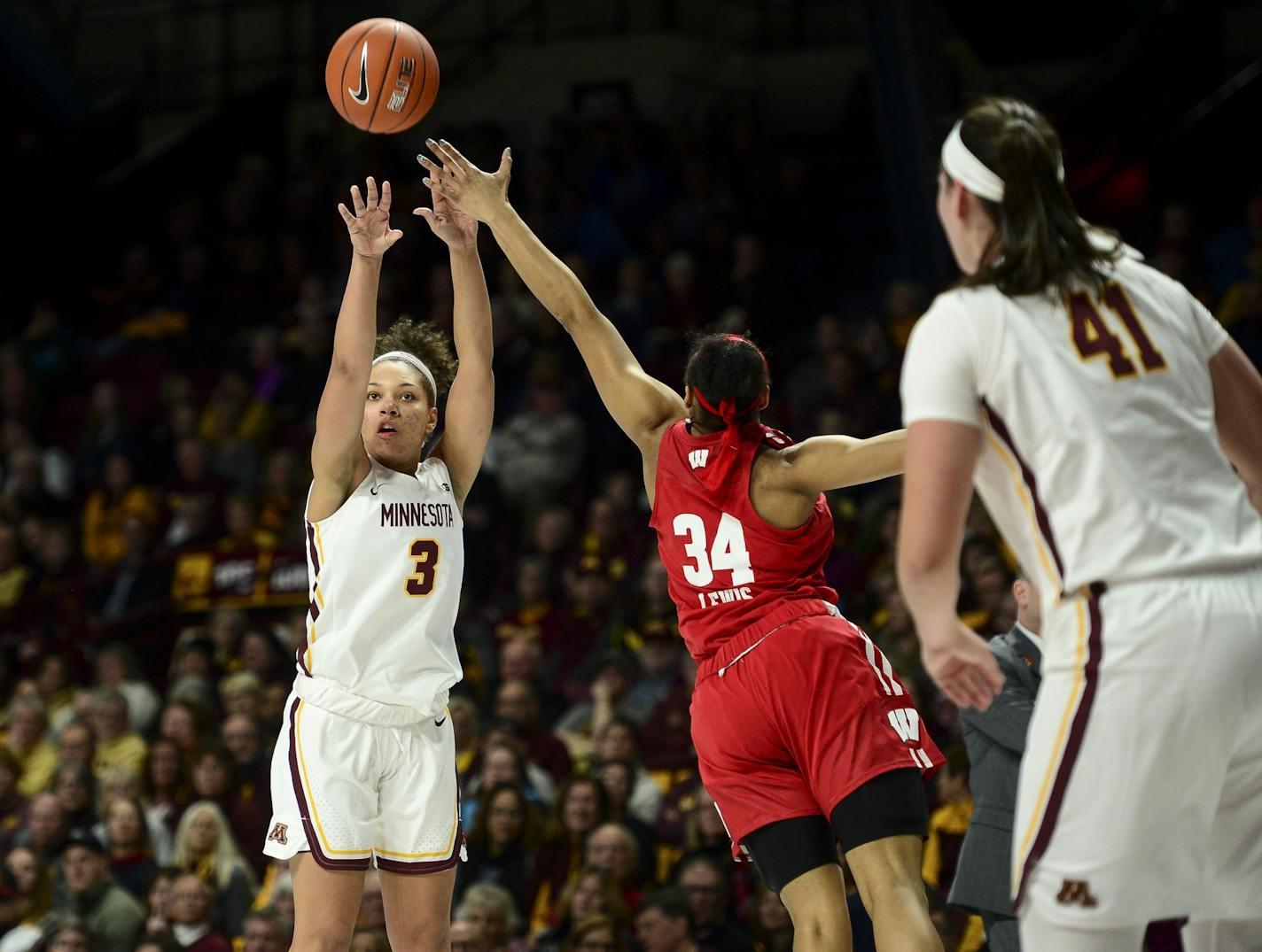 Minnesota Golden Gophers guard/forward Destiny Pitts (3) hit a 3-pointer while being defended by Wisconsin Badgers forward Imani Lewis (34).