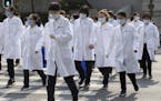Medical workers from Beijing walk near a park during a day off as the city of Wuhan slowly loosens up ahead of a lifting of the two month long lockdow