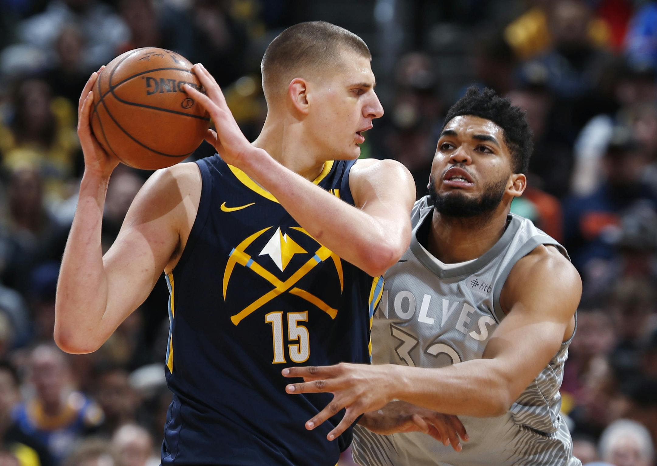 Minnesota Timberwolves center Karl-Anthony Towns, right, tries to steal the ball from Denver Nuggets center Nikola Jokic during the first half of an NBA basketball game Thursday, April 5, 2018, in Denver. (AP Photo/David Zalubowski)