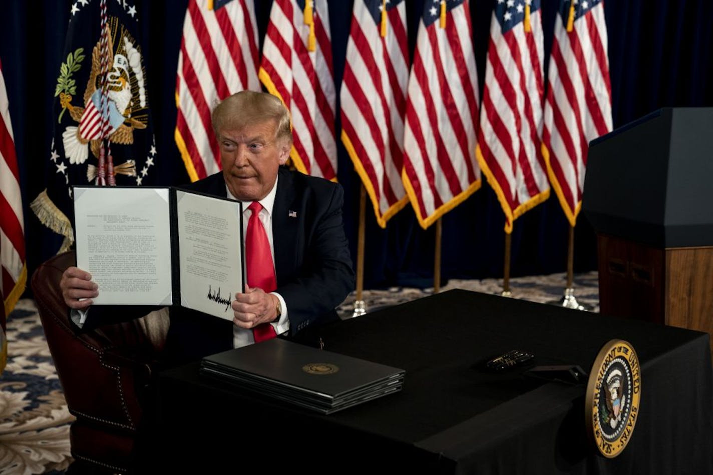 President Donald Trump during an executive order signing at Trump National Golf Club in Bedminster, N.J., Aug. 8, 2020. Businesses are grappling with difficult legal and logistical questions about how to respond to the president's payroll-tax holiday order.