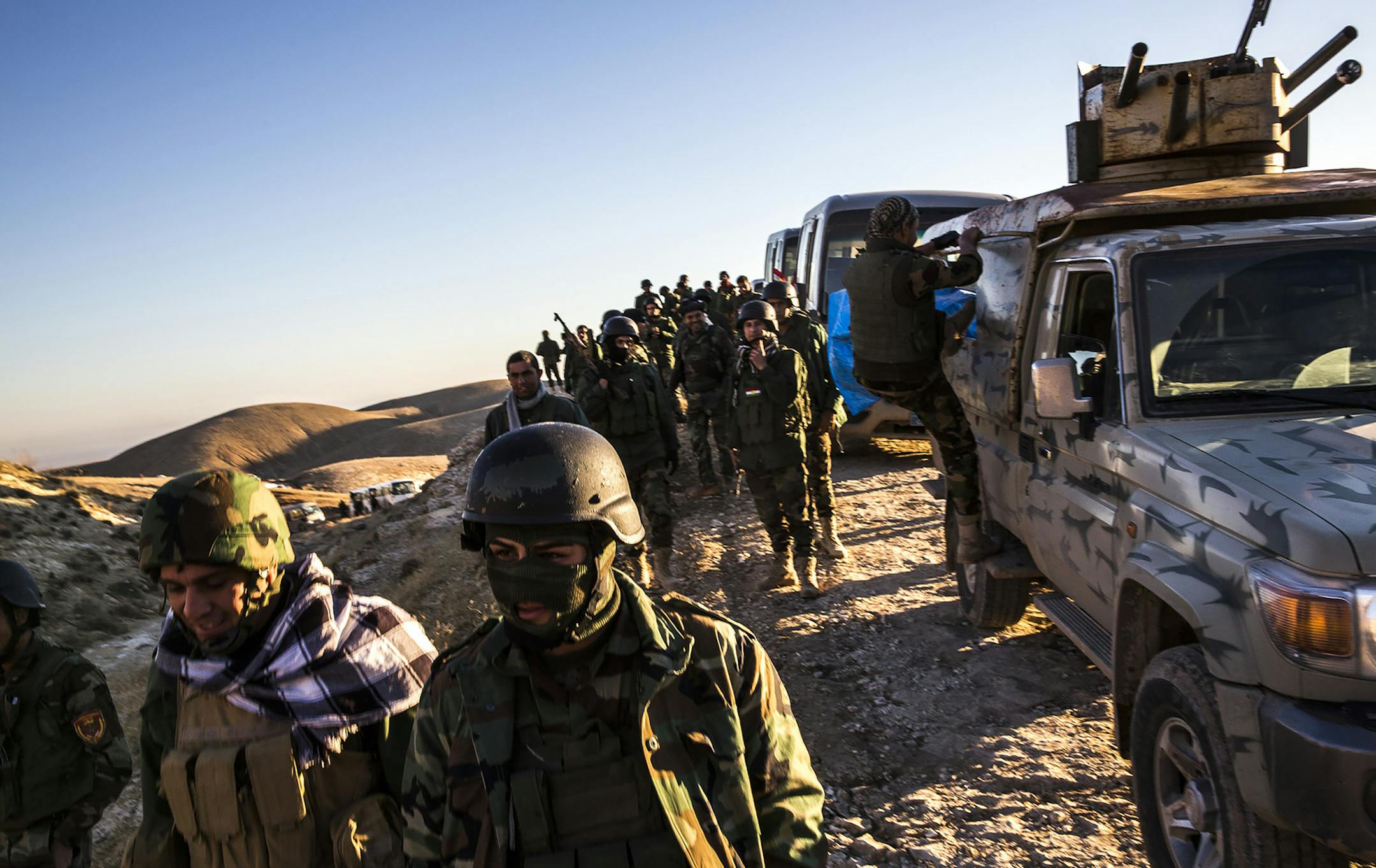 Peshmerga fighters, wait in a long convoy atop Mount Sinjar, in Iraq, Nov. 12, 2015. Kurdish-led forces Thursday gained control over a major jihadi supply line between Syria and the Iraqi city of Mosul as part of a broader offensive to reclaim the town of Sinjar. (Bryan Denton/The New York Times) ORG XMIT: MIN2015111216054850