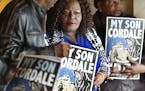 Kimberly Handy Jones flanked by Clyde McLemore left and her sister Nanette Adams held a poster of her son Cordale Handy who was killed by St. Paul Pol