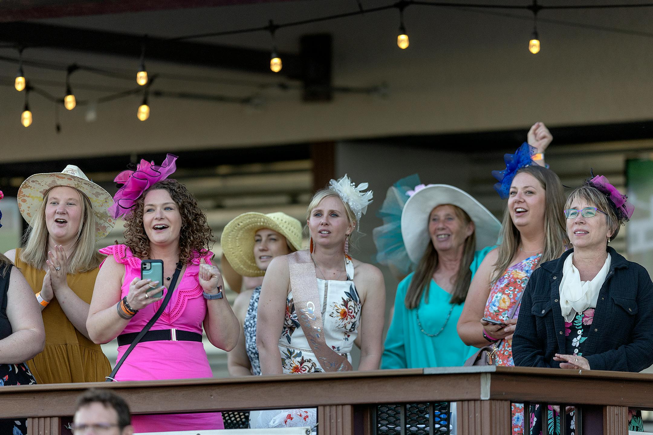 Race fans cheer on a race as they also celebrate a bachelorette party on opening night at Canterbury Park.