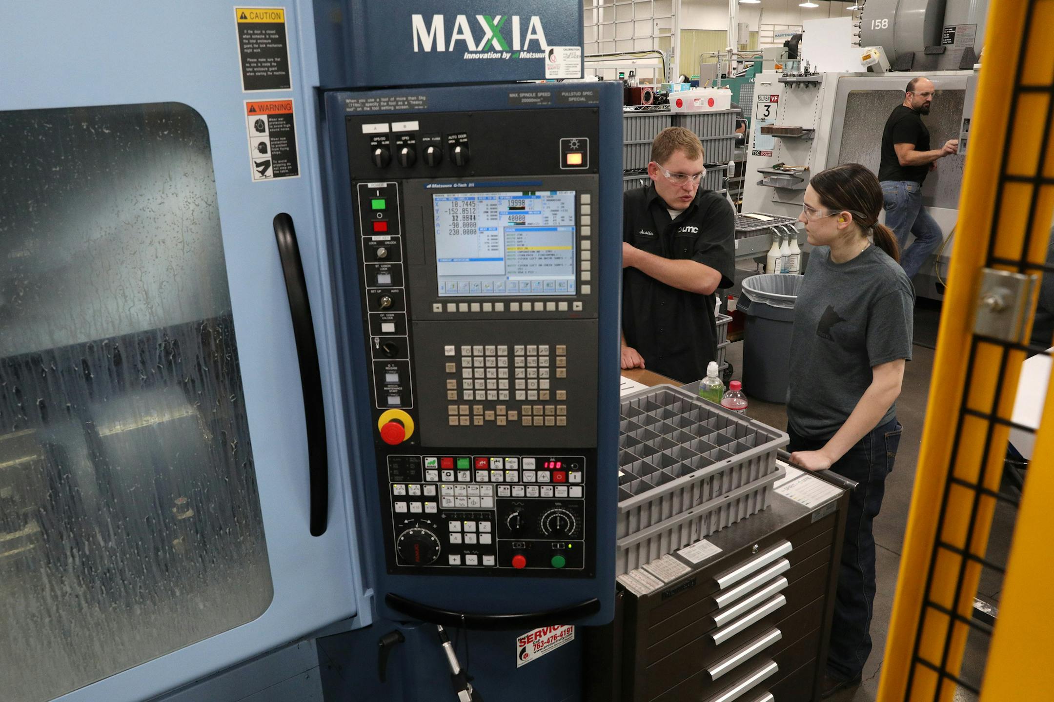 Ultra Machining employees work with a high precision milling machine, as it turned out parts for knee replacements, in this file photo of the Monticello company. (ANTHONY SOUFFLE &#x2022; Star Tribune)