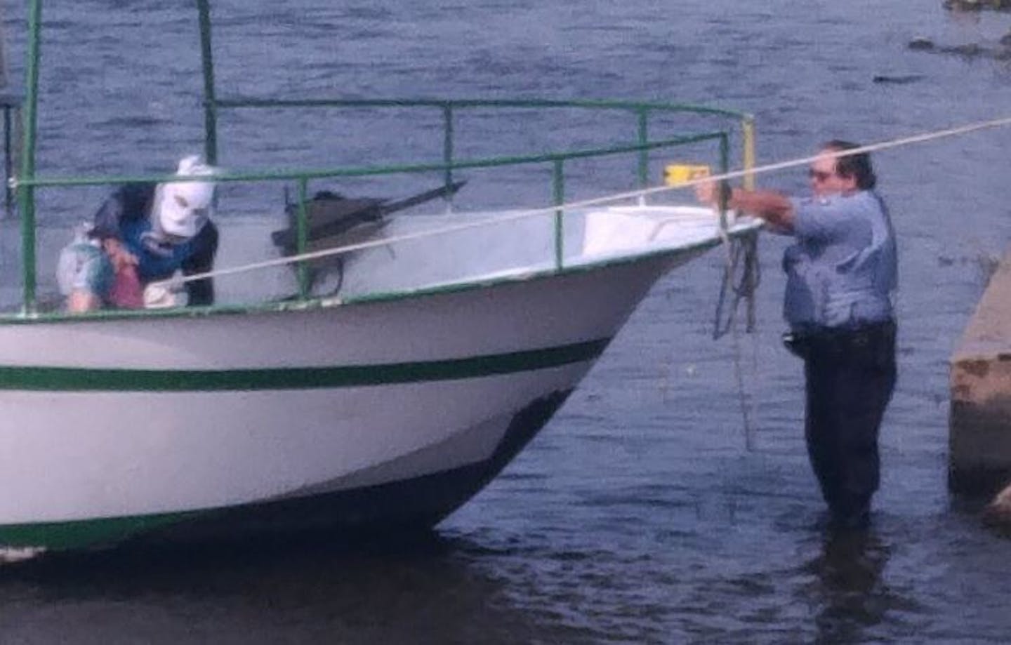 A police officer aims a Taser at a masked man accused of stealing a boat from Nicollet Island in Minneapolis.