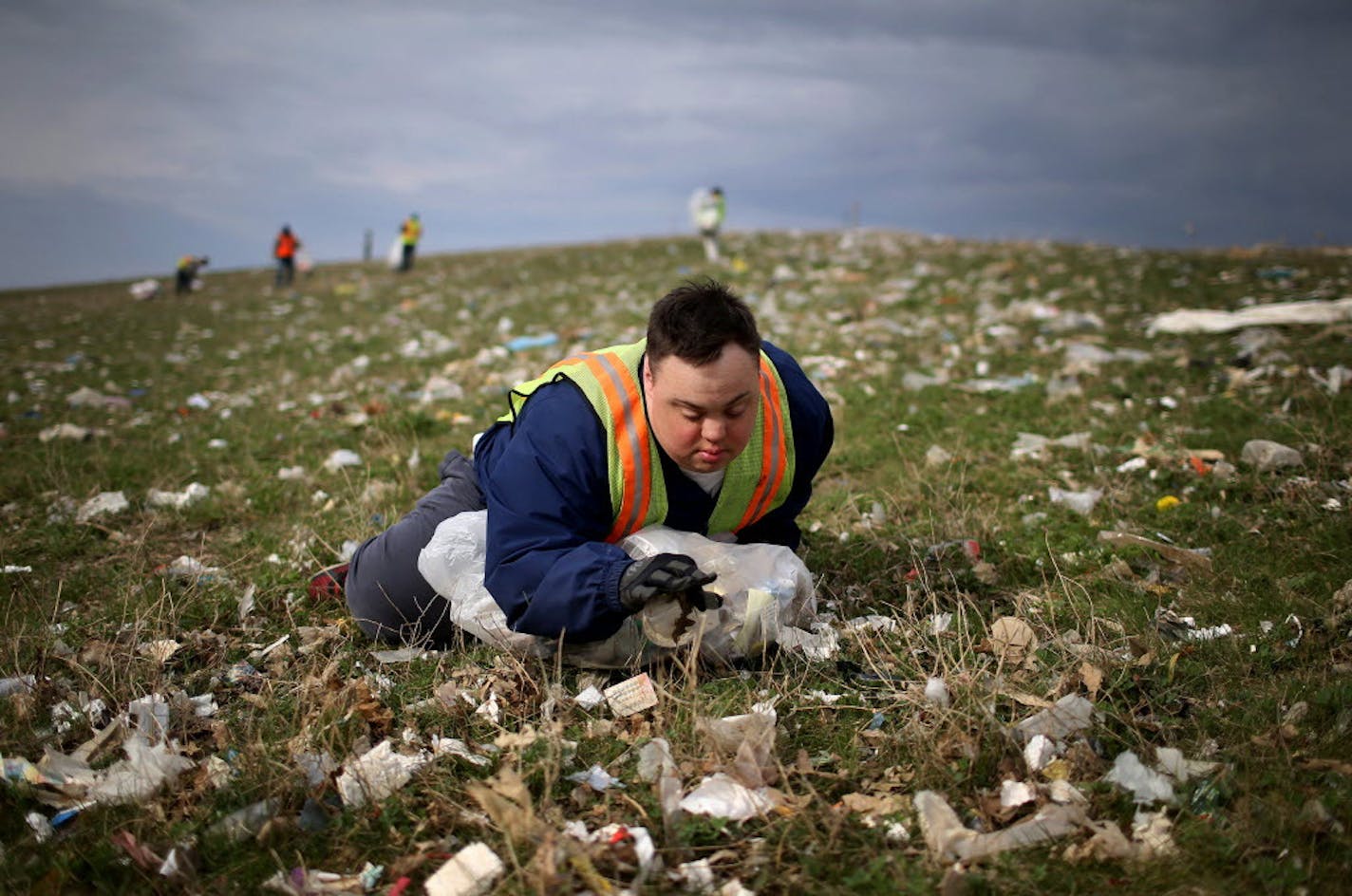 Scott Rhude of Willmar sat in a field of garbage while working on assignment with a sheltered workshop "enclave."