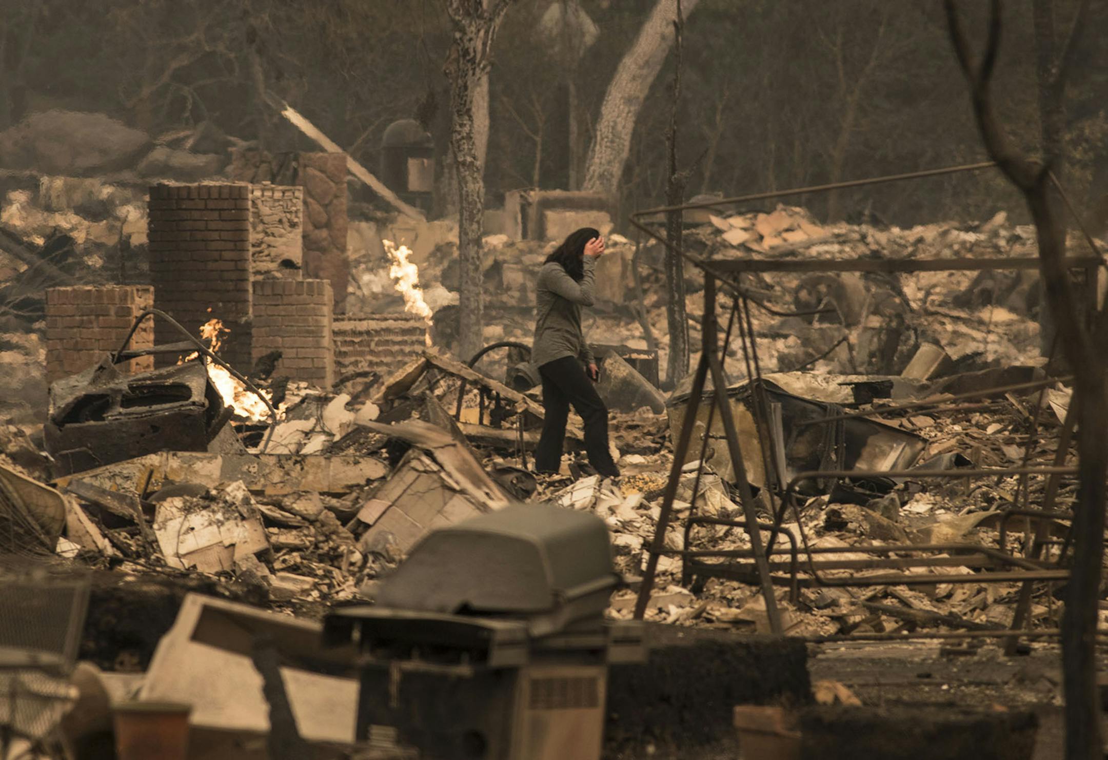 A Fountaingrove Village homeowner surveys her destroyed home she and her husband have owned for 4 years in Santa Rosa Monday, Oct. 9, 2017 in Santa Rosa, Calif. (Brian van der Brug/Los Angeles Times/TNS)