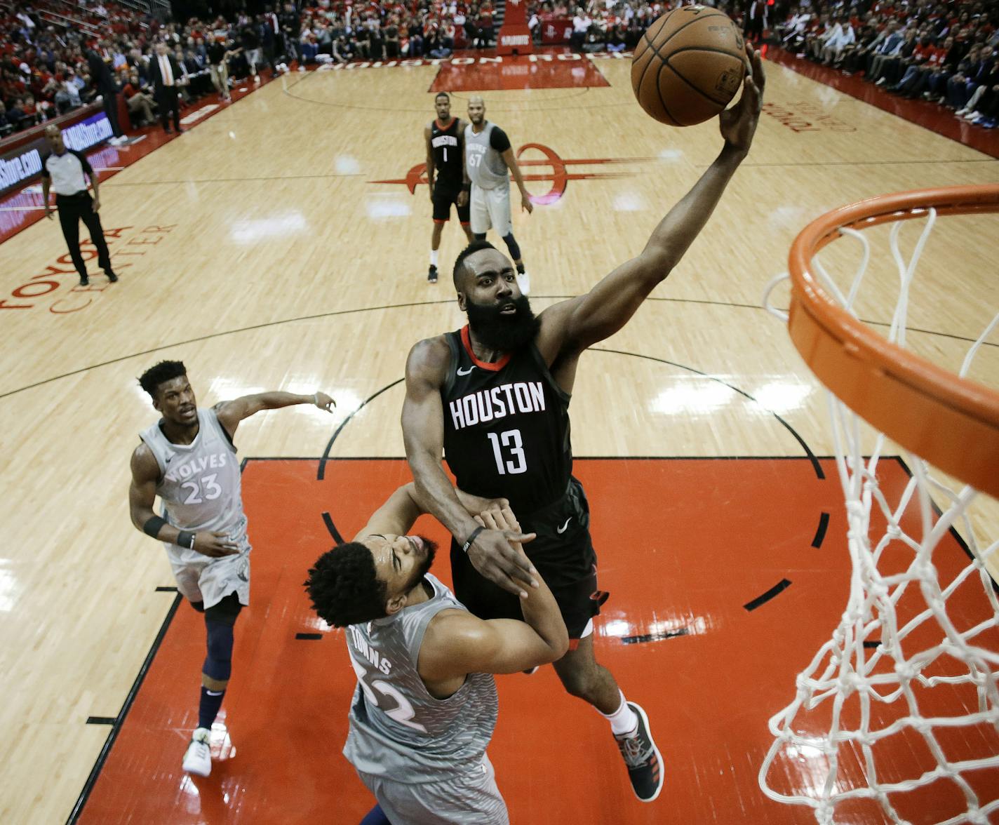 Houston Rockets guard James Harden (13) drives to the basket over Minnesota Timberwolves center Karl-Anthony Towns during the first half in Game 2 of a first-round NBA basketball playoff series Wednesday, April 18, 2018, in Houston. (AP Photo/Eric Christian Smith)