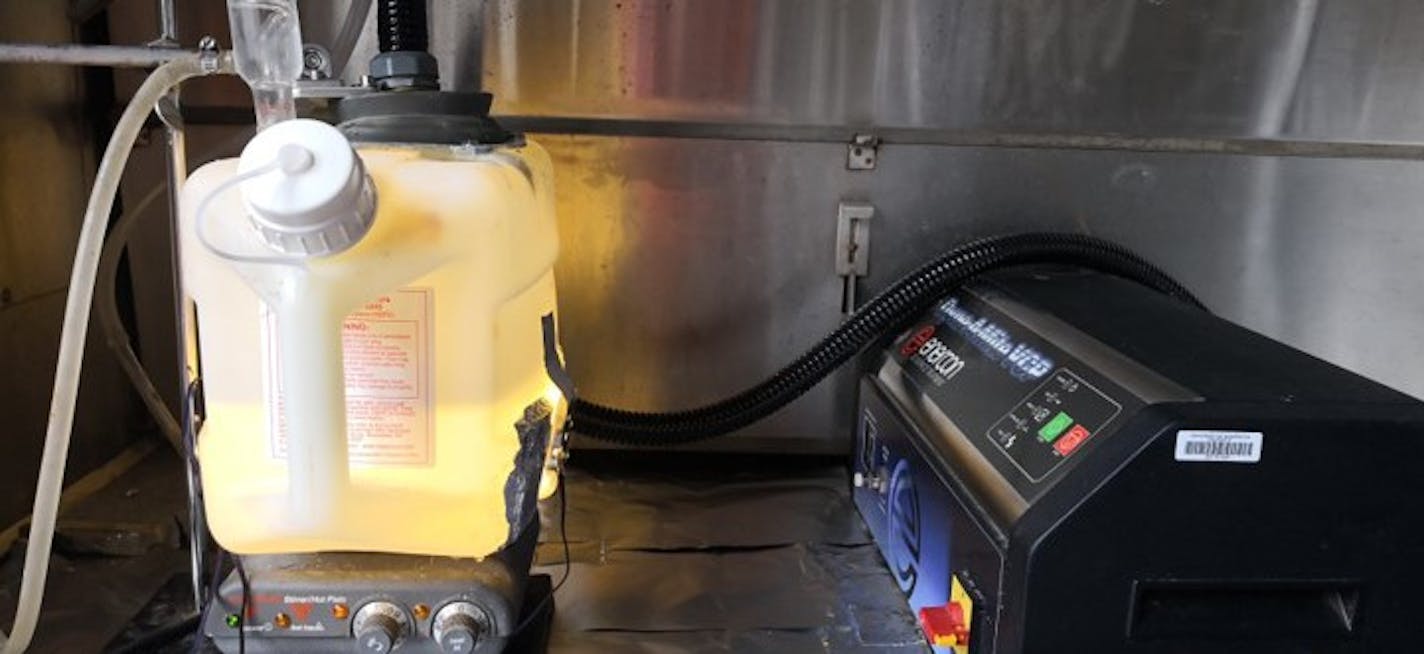 One of Roger Ruan's liquid nitrogen generator prototypes. The tank on the left has water and a catalyst, a plasma jet comes in from the top and a UV light comes in from the side. The black box on the right is the power supply and controller for the plasma jet generation. (Photo courtesy Roger Ruan)