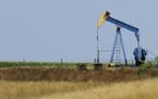 A field oil pumper is seen in a farm field Friday, July 13, 2012 near Edinburg, Ill. (AP Photo/Seth Perlman) ORG XMIT: ILSP101