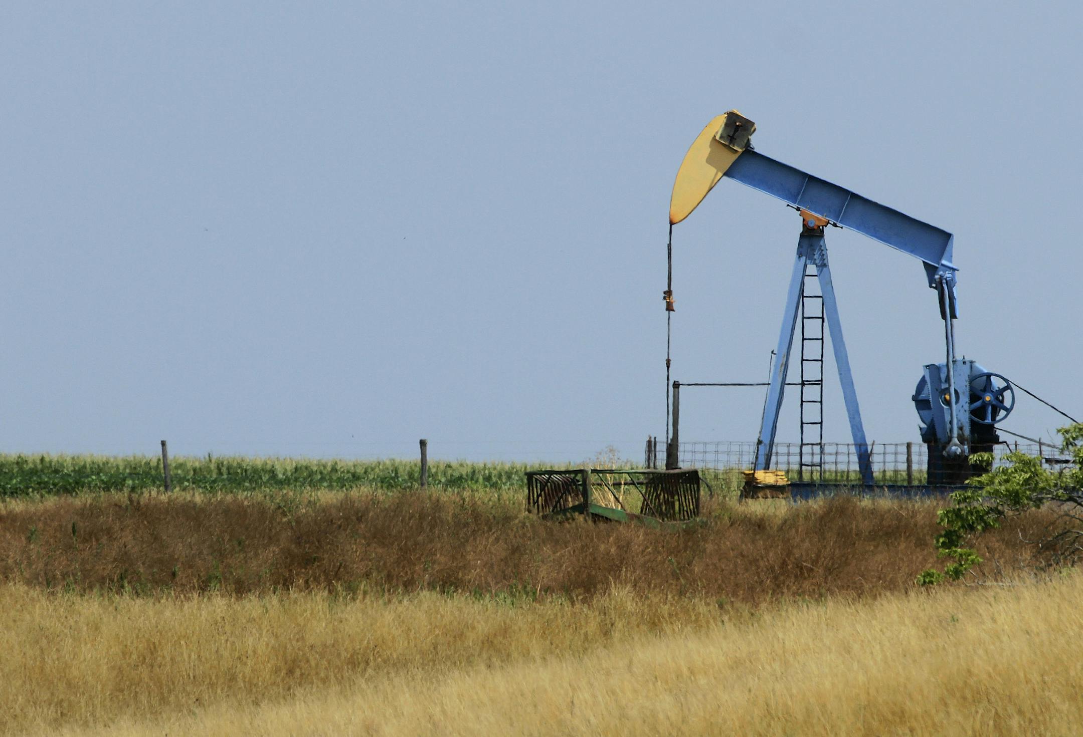 A field oil pumper is seen in a farm field Friday, July 13, 2012 near Edinburg, Ill. (AP Photo/Seth Perlman) ORG XMIT: ILSP101