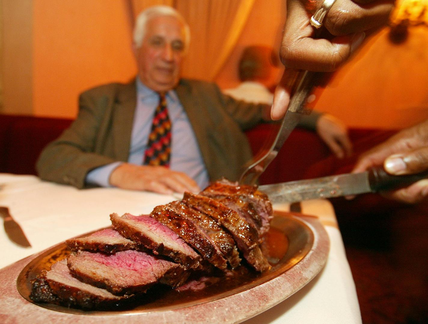 Sid Hartman, right, is served a "Silver Butter Knife" steak by Frank Adams at Murray's, Minneapolis, Mn. The Booth Sid is sitting in his booth. ORG XMIT: MIN2017121120453259