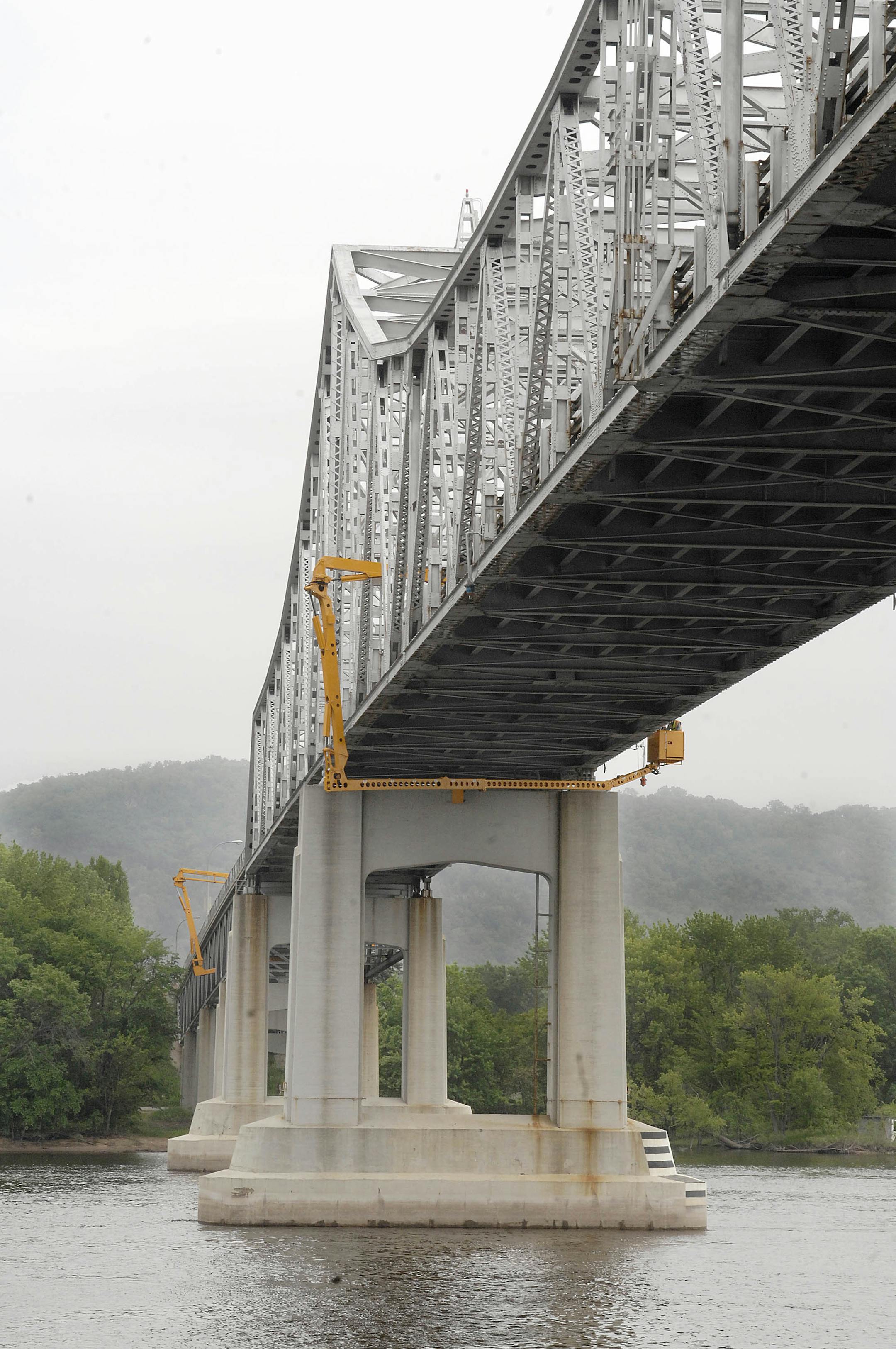Crews from the Minnesota Department of Transportation use snooper trucks in order to access gusset plates underneath the Hwy. 43 bridge on Wednesdayin Winona, Minn. Ferry boats, costing the city $85,000 a week, will replace the bridge for now.