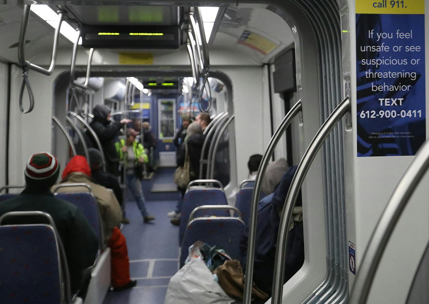 A Blue Line light-rail train in 2019 featuring a sign telling riders how to text if they feel unsafe or see suspicious behavior.