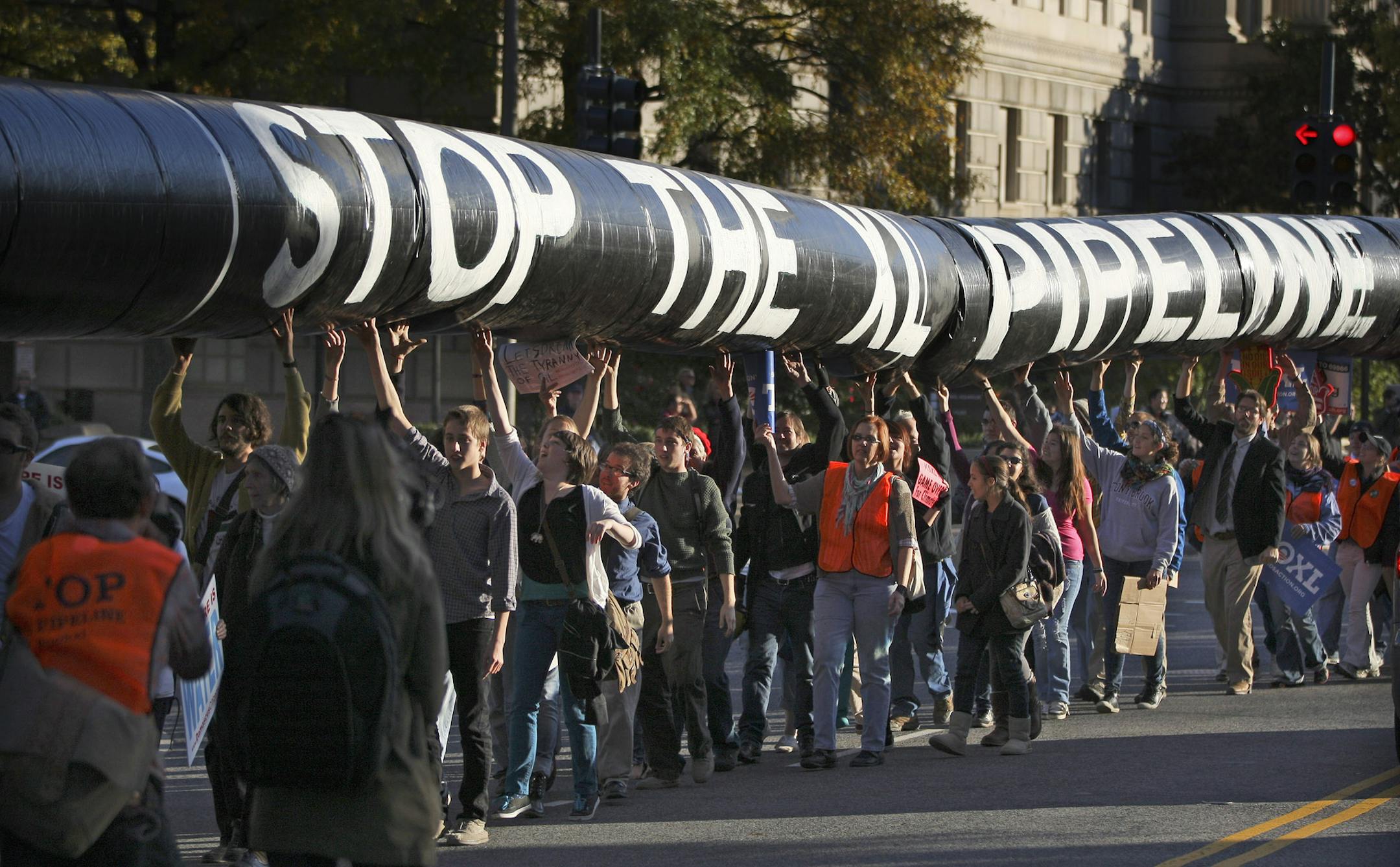 FILE PHOTO / BEST BLOOMBERG PHOTOS FOR 2011: A mock oil pipeline is carried during a Keystone XL tar sands oil pipeline demonstration near the White House in Washington, D.C., U.S., on Sunday, Nov. 6, 2011. Pipeline opponents say extracting crude from sand emits three times more carbon than conventional oil production, contributing to global warming that Obama pledged to fight. They say their protest in Washington reflects public anger at corporate greed. Photographer: Andrew Harrer/Bloomberg OR