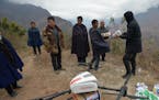 Chinese workers prepare to use a UAV (unmanned aerial vehicle), or drone, of Chinese online retailer JD.com to deliver medicines to a remote "cliff vi