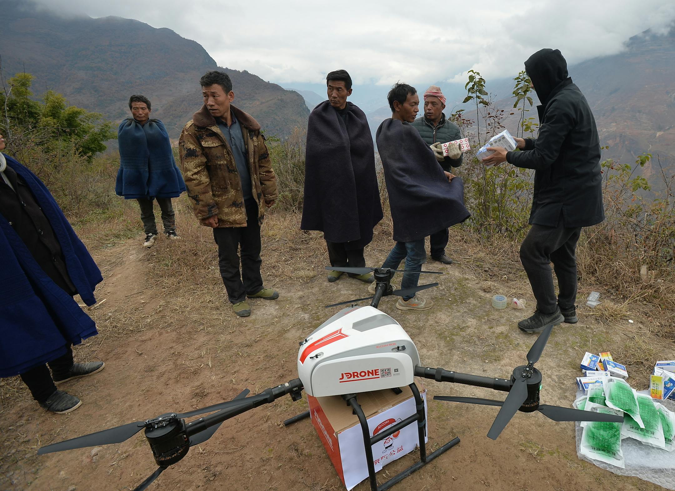 Chinese workers prepare to use a UAV (unmanned aerial vehicle), or drone, of Chinese online retailer JD.com to deliver medicines to a remote "cliff village" in Zhaojue county, Liangshan Yi Autonomous Prefecture, southwest China's Sichuan province, 14 December 2017. A UAV (unmanned aerial vehicle), or drone, carrying medicines hovered above mountainous area to deliver them to a remote "cliff village" in Zhaojue county, southwest China's Sichuan province, on Thursday (14 December 2017). The drone