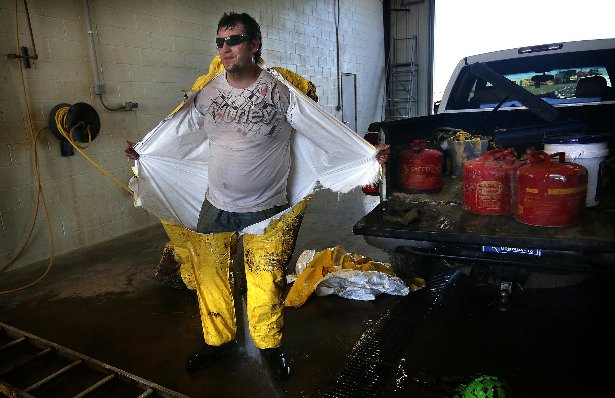 Andrew Klefstad removed the protective suit he used while cleaning a sludge holding tank. ] (JIM GEHRZ/STAR TRIBUNE) / September 26, 2013, Dickinson, ND ñ BACKGROUND INFORMATION- PHOTOS FOR USE IN FIRST PART OF NORTH DAKOTA OIL BOOM PROJECT: Andrew Klefstad, 28, is the general manager of an environmental company that cleans up frac gel-spills and scrubs sludge off trucks that serve the needs of the oil boom in the Bakken oil fields of North Dakota. Klefstad, works in the oil fields for thre