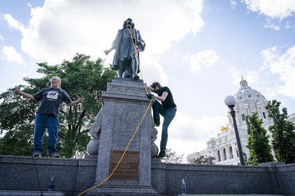 Activists put ropes around the neck of the Christopher Columbus statue, preparing to pull it down.