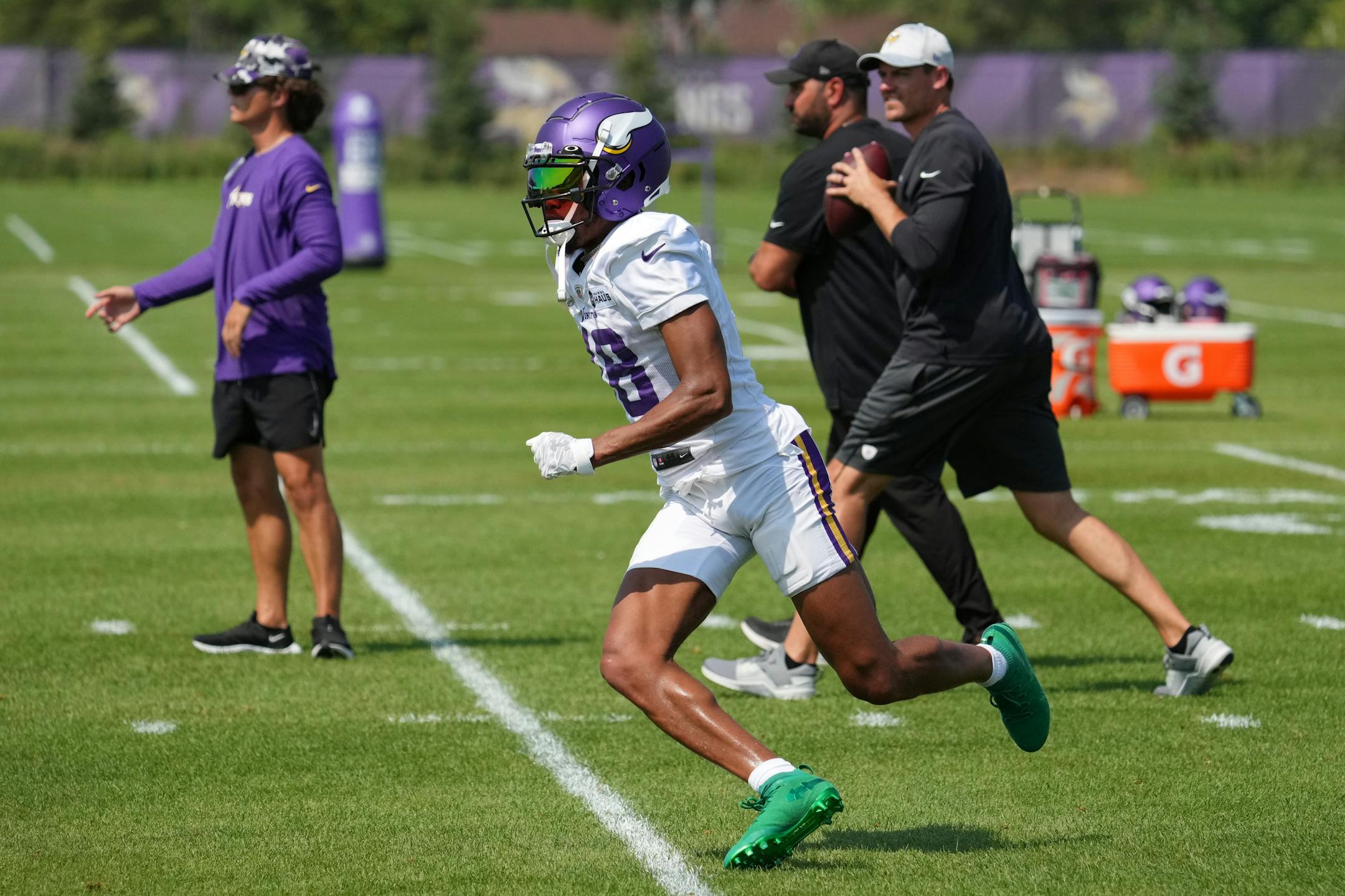 Minnesota Vikings wide receiver Justin Jefferson (18) raced to catch a pass from head coach Kevin O'Connell during training camp.