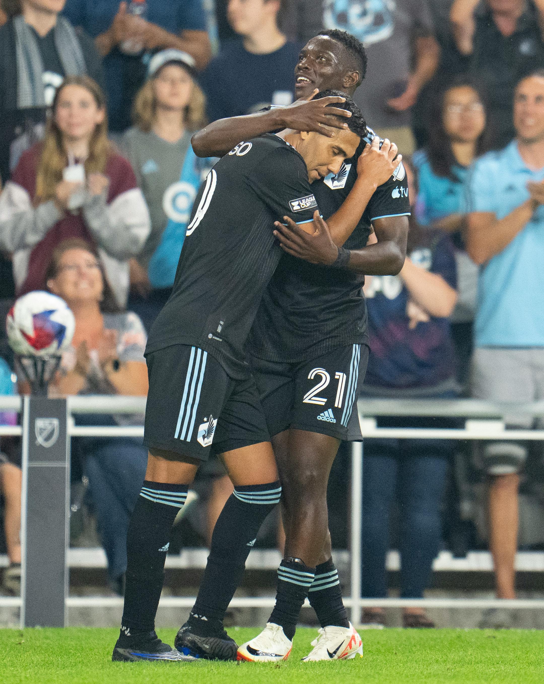 Minnesota United midfielder Emanuel Reynoso embraces Loons forward Bongokuhle Hlongwane (21) after scoring a goal against Puebla in the second half.