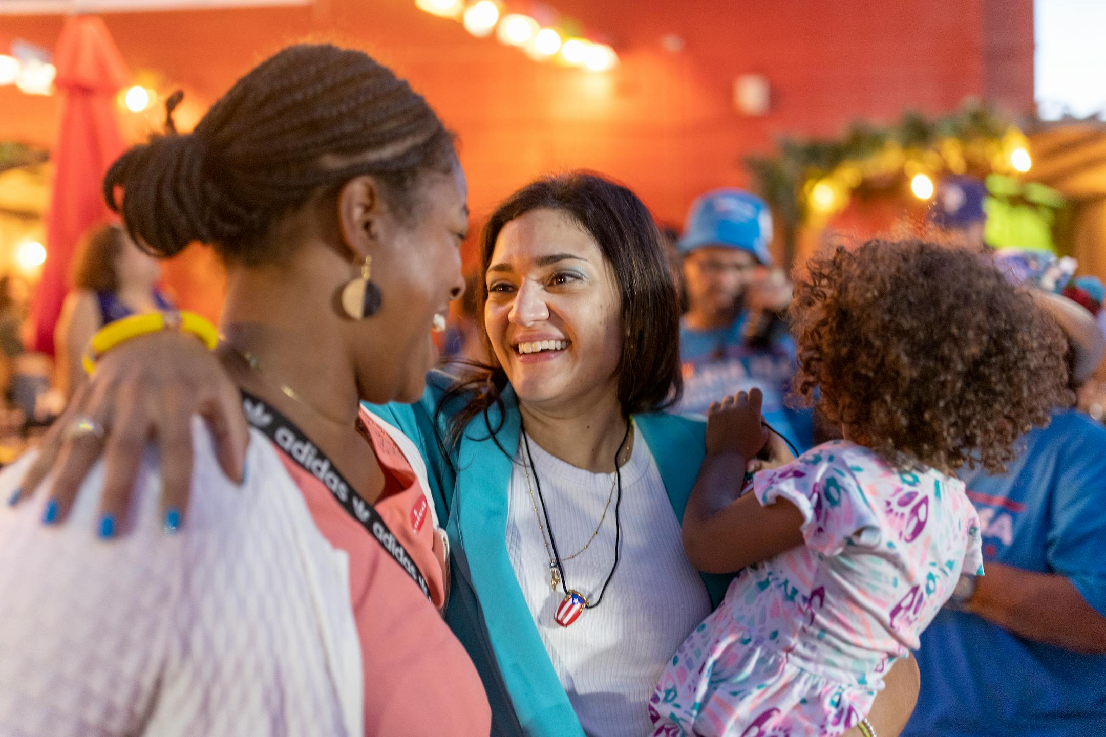 Holding her daughter Loiza, Maria Isa Perez-Hedges gets hugs from her supporters as she celebrates her win at a gathering at El Burrito Mercado in St. Paul.
