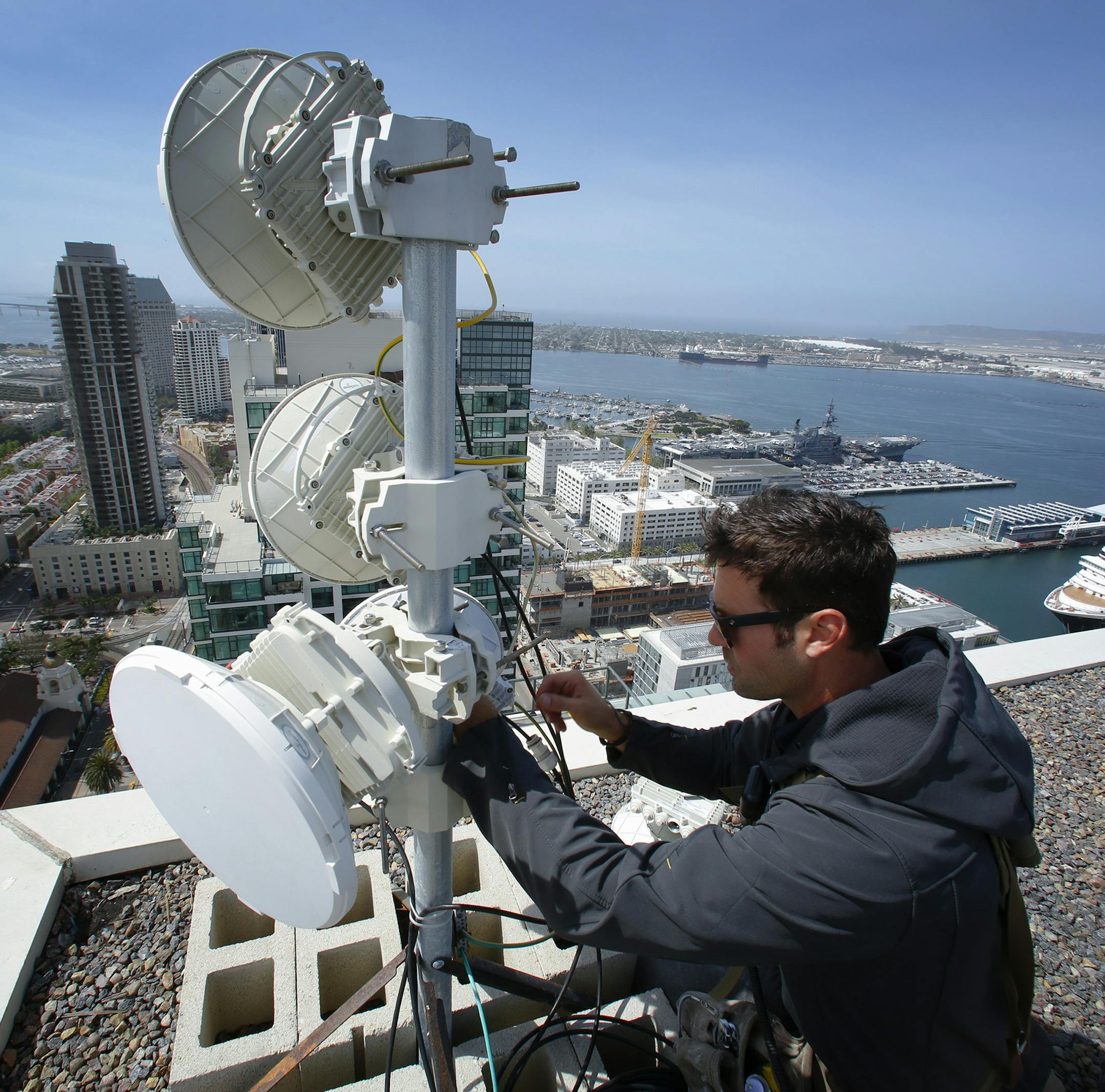 Webpass technician Adam Larnach installs an upgraded millimeter wave radio on the roof top of a high rise condo unit in downtown San Diego. The upgraded piece of hardware will increase internet bandwidth for download and upload. (Nelvin C. Cepeda/San Diego Union-Tribune/TNS) ORG XMIT: 1202551