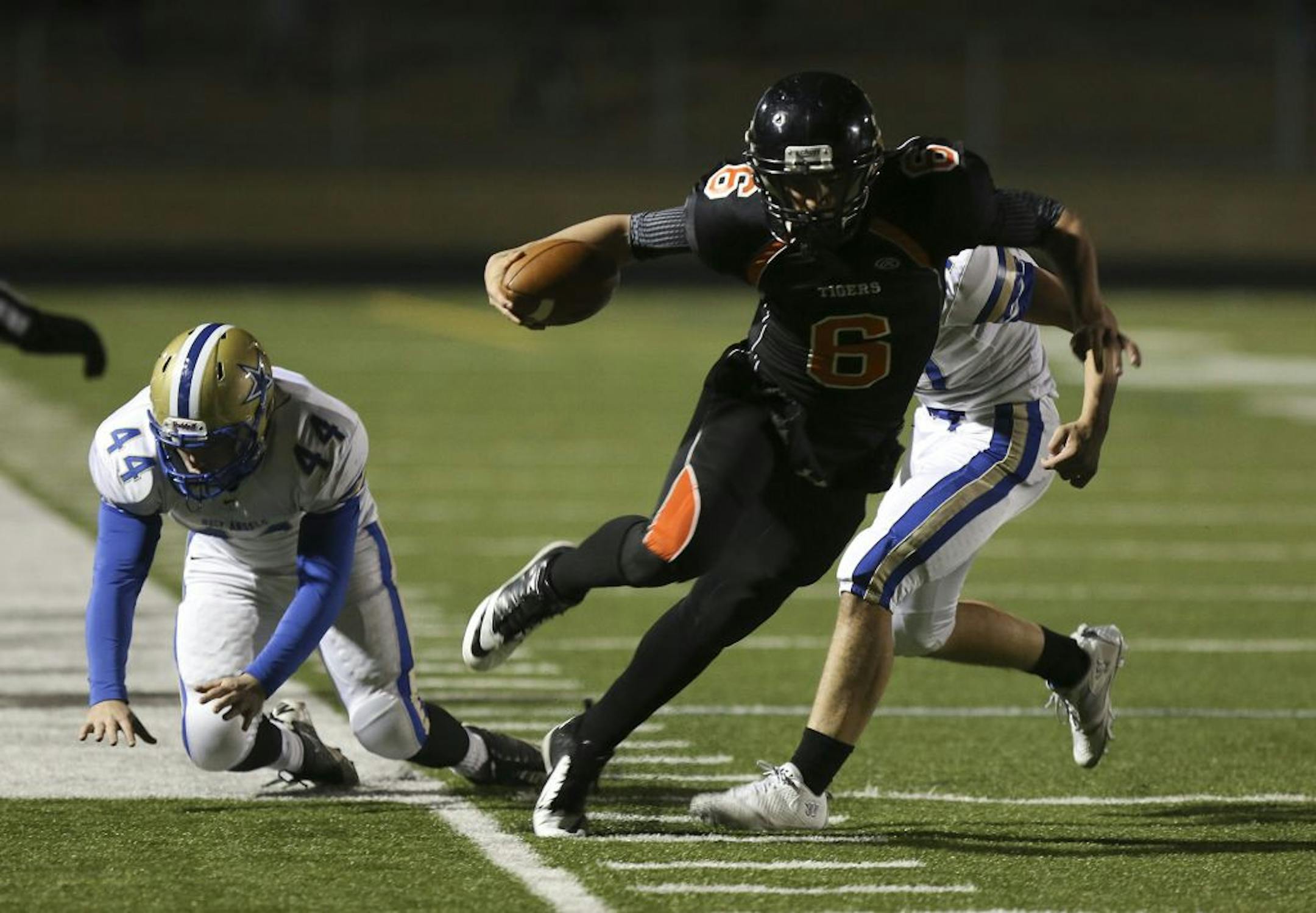 Farmington quarterback Darren Beenken stayed inbounds as he got past Holy Angels' Kevin Ness, left, and Connor Duffy during the first half of a game on Oct. 12. Photo by Kyndell Harkness • kharkness@startribune.com