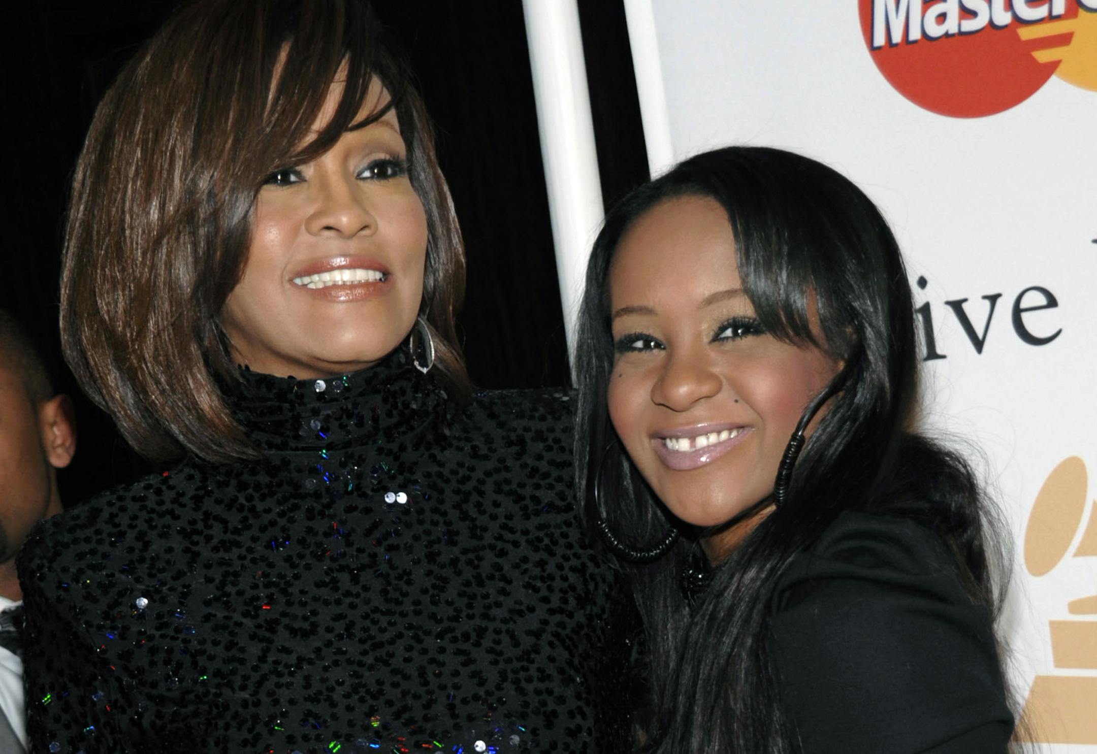 FILE - In this Feb. 12, 2011, file photo, singer Whitney Houston, left, and daughter Bobbi Kristina Brown arrive at an event in Beverly Hills, Calif. The daughter of late singer and entertainer Whitney Houston was found Saturday, Jan. 31, 2015, unresponsive in a bathtub by her husband and a friend and taken to an Atlanta-area hospital. The incident remains under investigation. (AP Photo/Dan Steinberg, File)