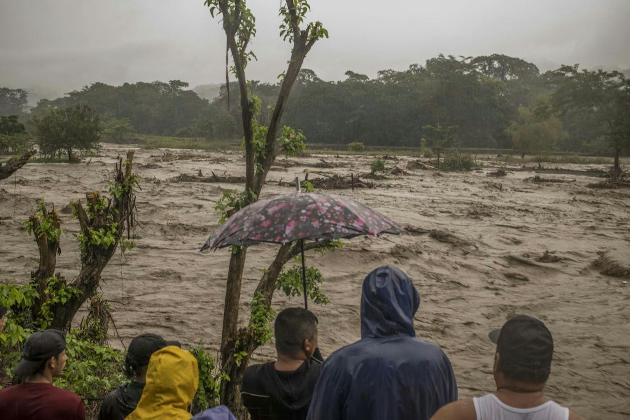 People look out at the Rio Machaula's high water level cause by Hurricane Iota in San Pedro Sula, Honduras, on Tuesday, Nov. 17, 2020. The hurricane is barreling across parts of Central America that are still reeling from Hurricane Eta's impact earlier this month.