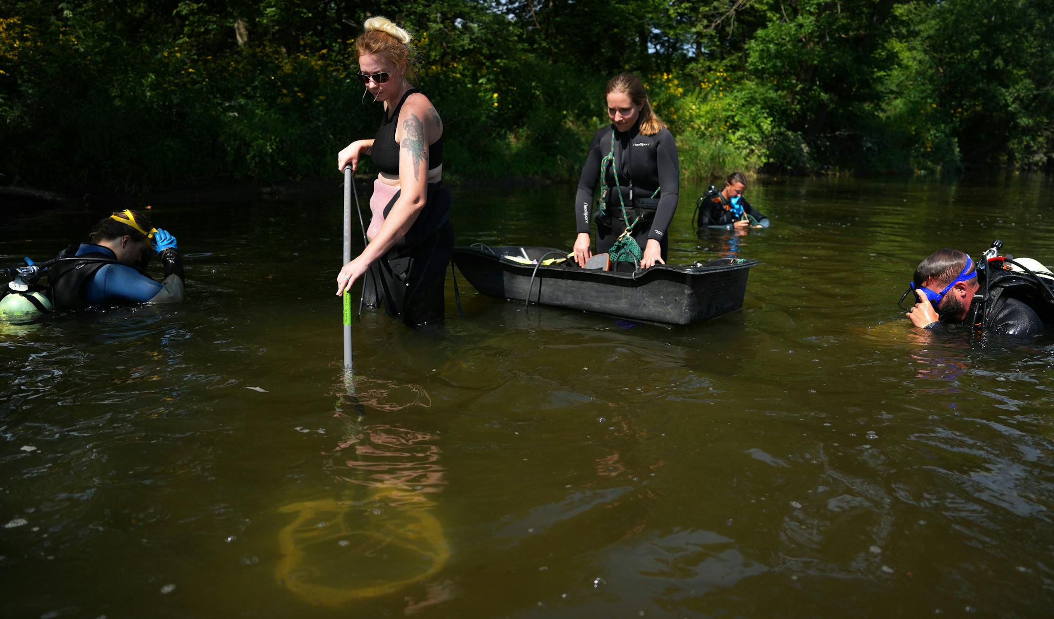 Lindsay Ohlman, center, a propagation biologist with the Minnesota DNR, uses a Biomark PIT Tag reader to scan the river bottom as she and a team surveyed a population of black sandshell and mucket mussels they'd previously released in a section of the Cedar River.