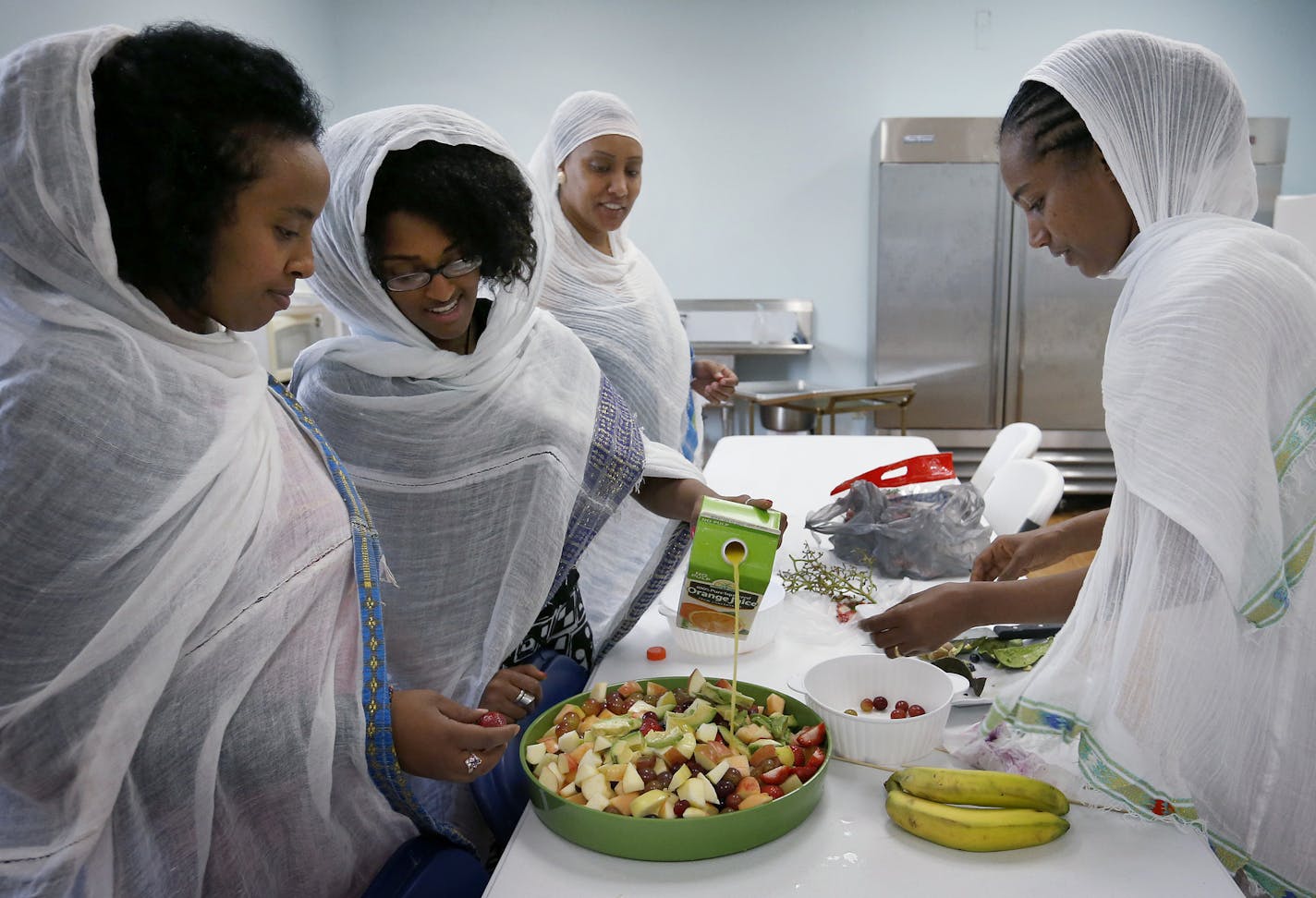 Hurit Gishen, Egeziharya Yilma, Hilena Yarede and Sara Baheru prepared food for a meeting at the Ethiopian Orthodox Tewahedo Church in Minneapolis. A building that once housed an IT supplier on Minnehaha Avenue has been purchased by an Ethiopian group and transformed into a church. ] CARLOS GONZALEZ cgonzalez@startribune.com - August 26, 2015, Minneapolis, MN, A building that once housed an IT supplier on Minnahaha Avenue has been purchased by an Ethiopian group and transformed into a Christian