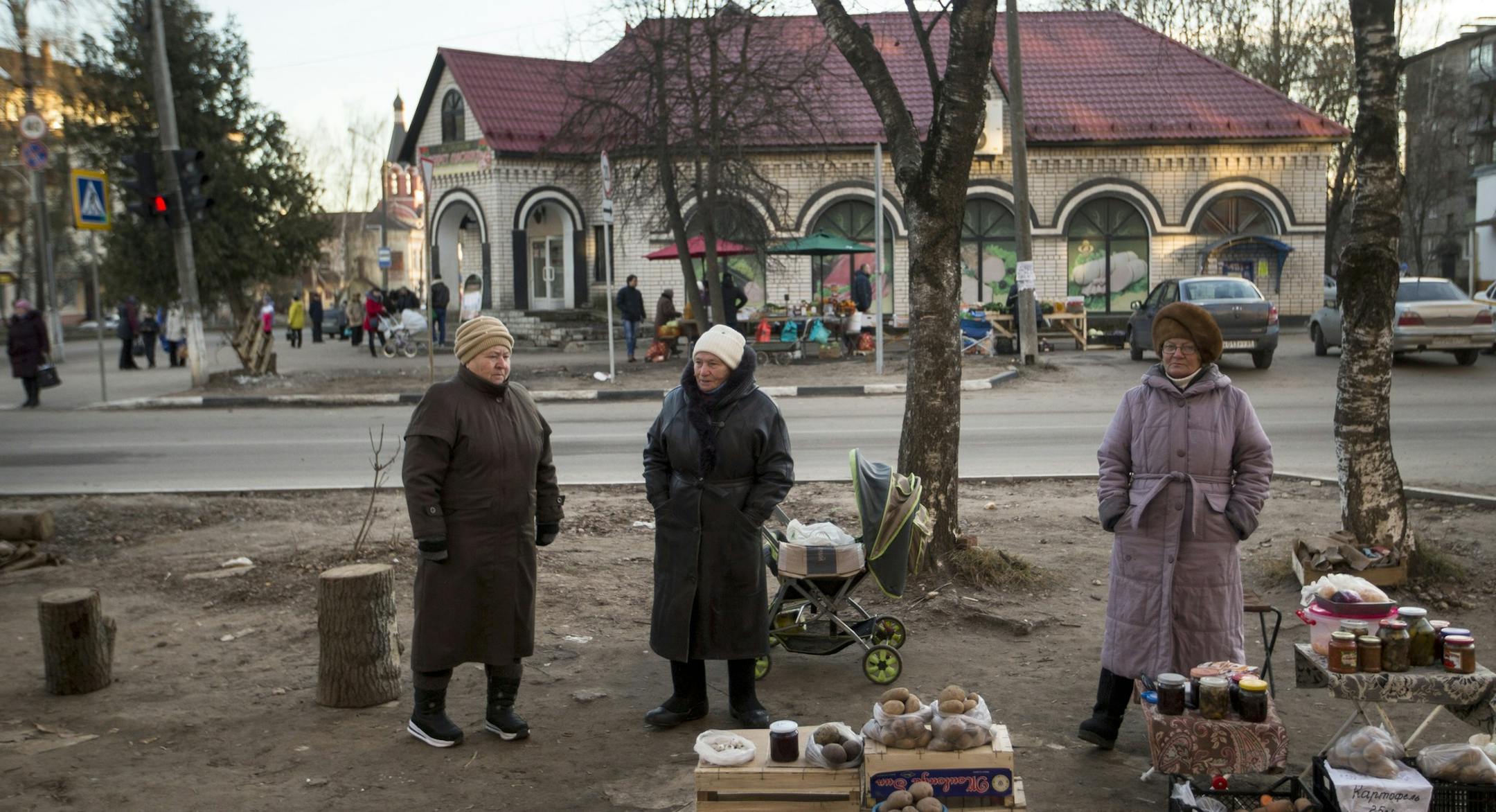 Local residents sell vegetable and homemade preserves in a street in the town of Rzhev, Tver region, about 240 kilometers (149 miles) west of Moscow, Russia, Wednesday, Dec. 9, 2015. A kilo of potato costs 25 rubles (about 30 cents). (AP Photo/Pavel Golovkin)