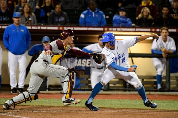 UCLA left fielder Jeremy Ydens (18) was tagged out at home by Minnesota catcher Eli Wilson (4) as shortstop Kevin Kendall (4) reached first on a field