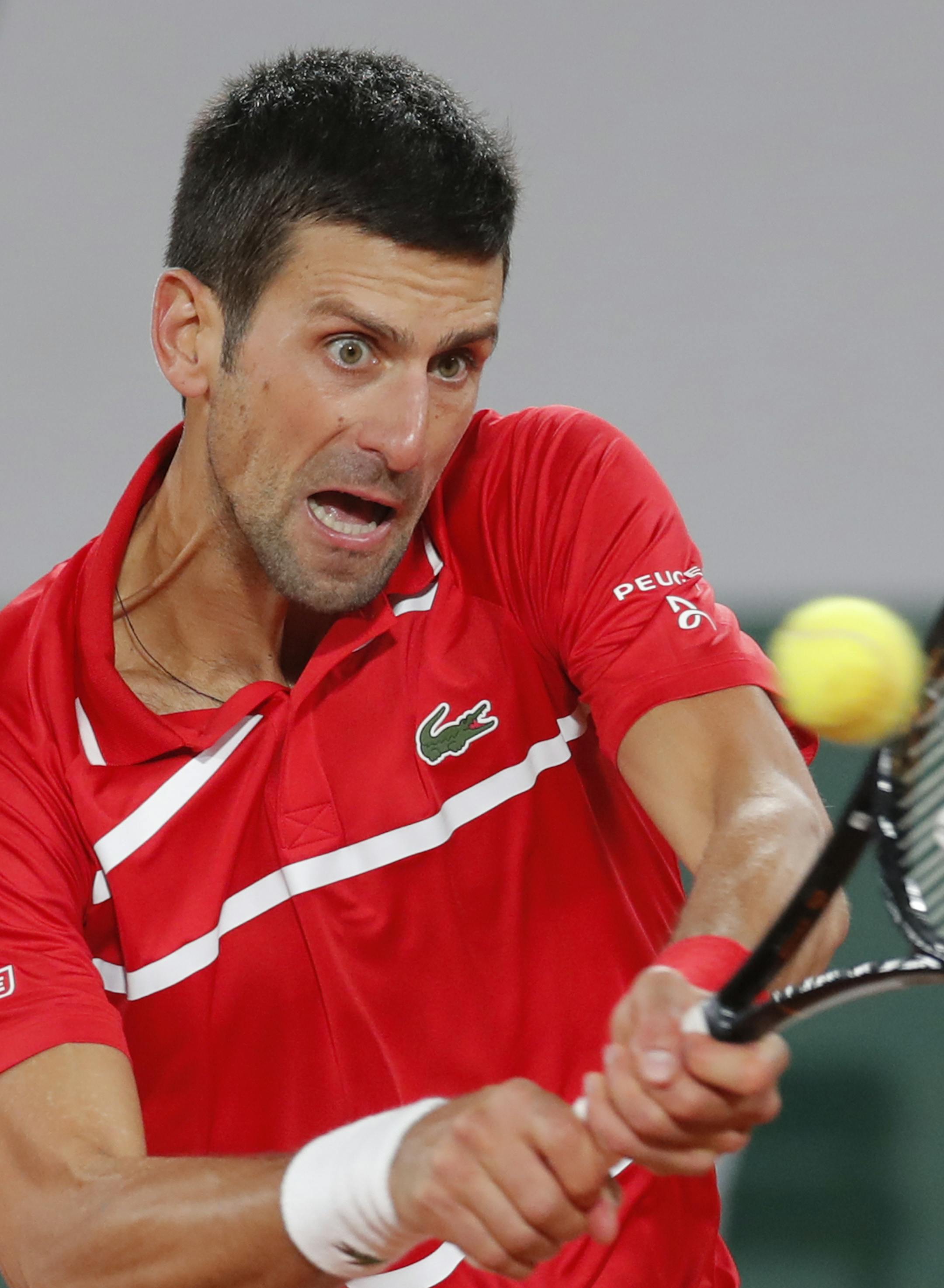 Serbia's Novak Djokovic plays a shot against Greece's Stefanos Tsitsipas in the semifinal match of the French Open tennis tournament at the Roland Garros stadium in Paris, France, Friday, Oct. 9, 2020. (AP Photo/Michel Euler)