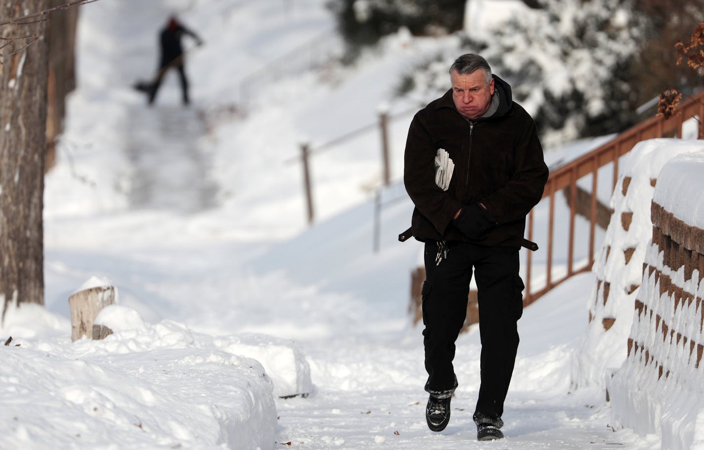 A man grimaces as he walks though the snow covered landscape Saturday in the northeast. ] ANTHONY SOUFFLE &#x2022; anthony.souffle@startribune.com Residents dig out after a heavy snow overnight Saturday, Dec. 17, 2016 in the northeast of Minneapolis.