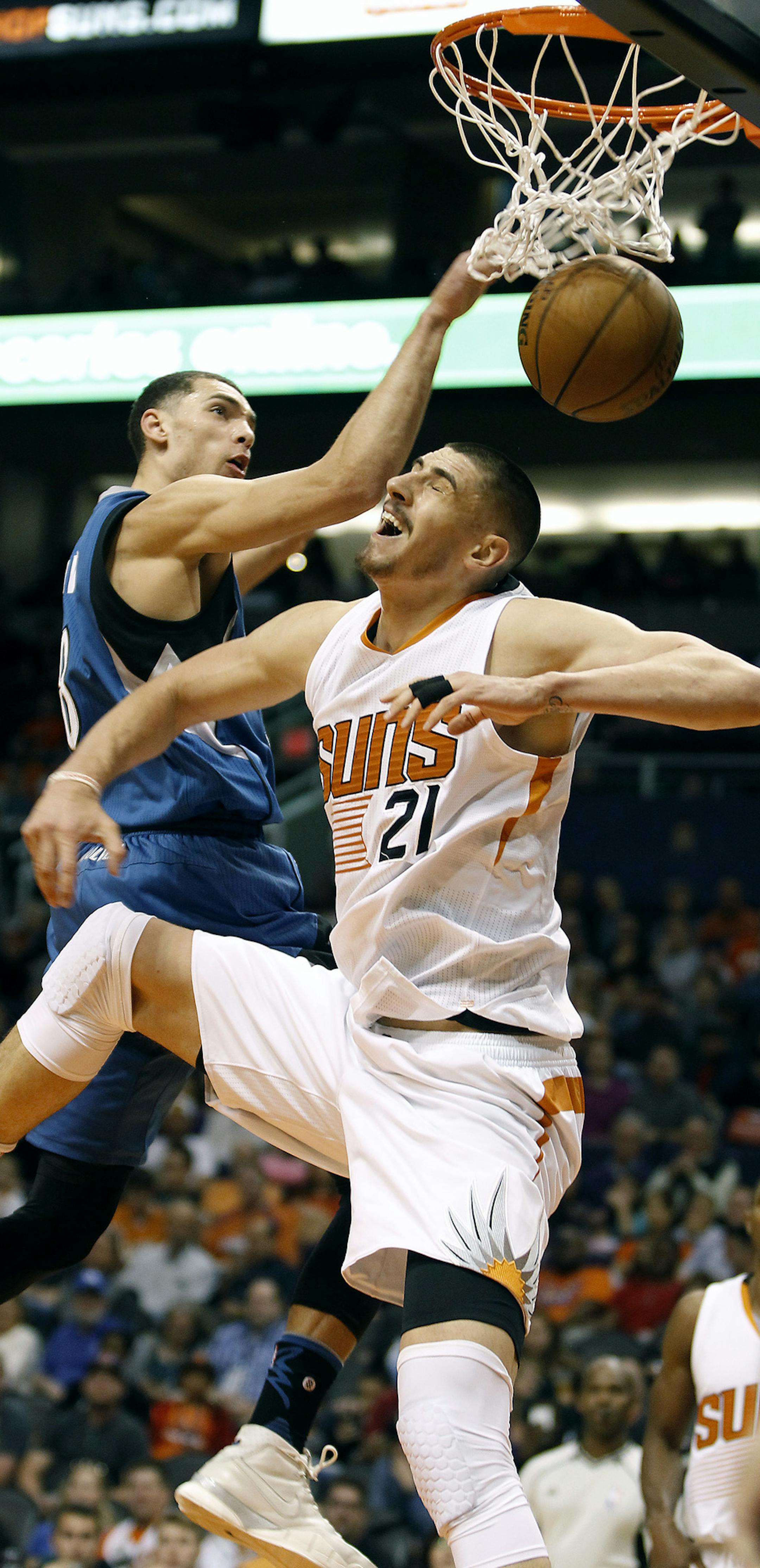 Minnesota Timberwolves guard Zach LaVine, left, dunks over Phoenix Suns center Alex Len (21) during the first half of an NBA basketball game, Friday, Nov. 25, 2016, in Phoenix. (AP Photo/Ralph Freso)