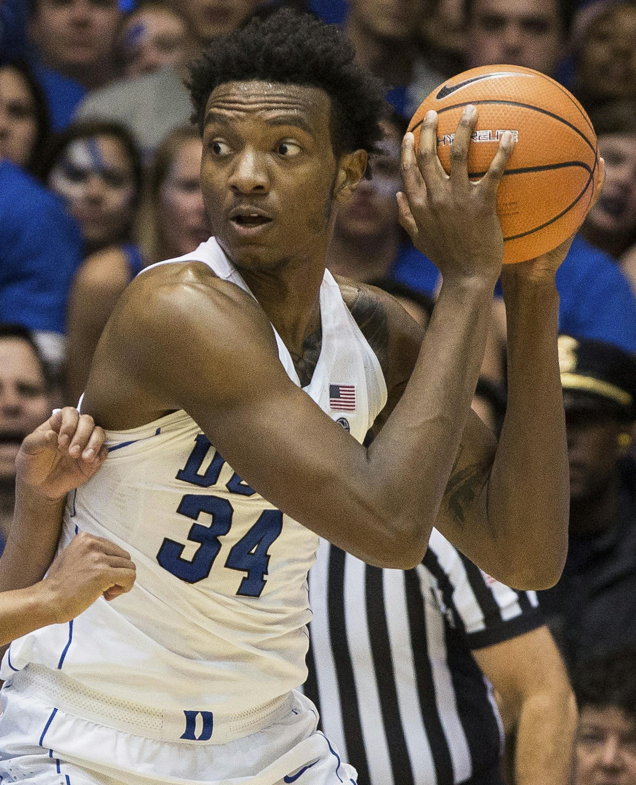 Duke's Wendell Carter Jr. (34) handles the ball in the post as North Carolina's Cameron Johnson (13) defends during the second half of an NCAA college basketball game in Durham, N.C., Saturday, March 3, 2018. Duke defeated North Carolina 74-64. (AP Photo/Ben McKeown) ORG XMIT: MIN2018031419382260