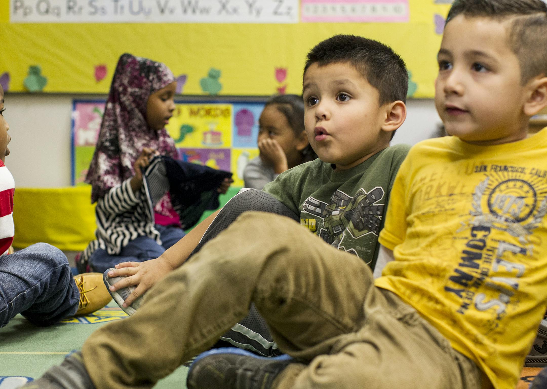 Preschool students Christian Berry, right, and Brandon Juarez follow along as an instructor reads a book at the Head Start Family Development Center in Coon Rapids October 6, 2014. (Courtney Perry/Special to the Star Tribune)