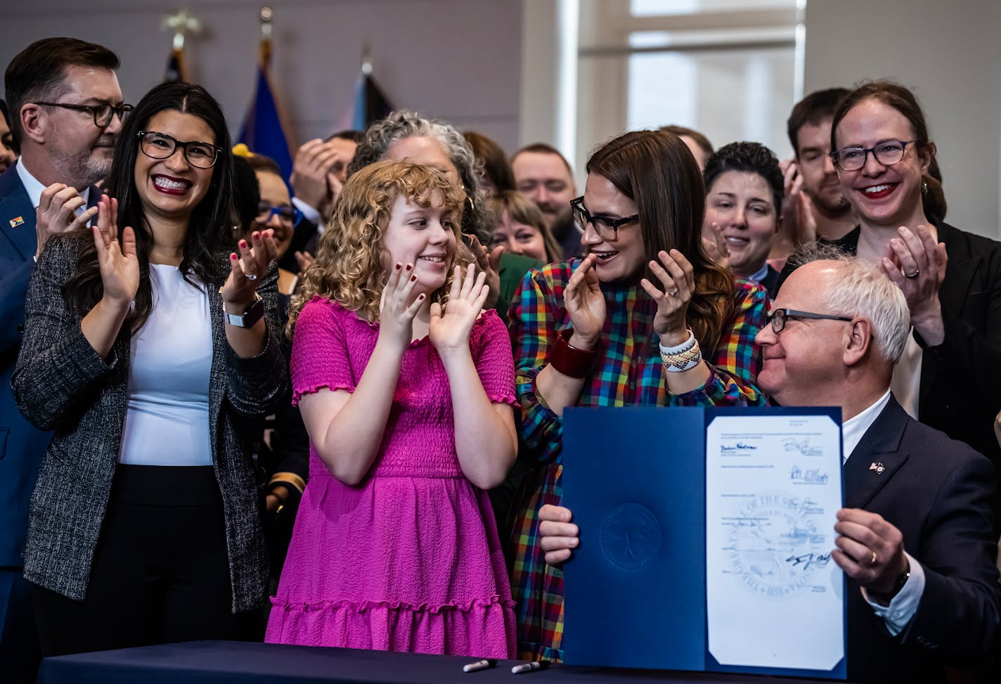 Hildie Edwards stands next to ally Lt. Governor Peggy Flanagan  and Governor Tim Walz signs a series of progressive bills including the "trans refuge" one in St. Paul, Minn., on Thursday, April 27, 2023. Hildie Edwards is a transgender activist who has helped pass legislation making Minnesota a refuge for transgender individuals. ] RICHARD TSONG-TAATARII • richard.tsong-taatarii@startribune.com