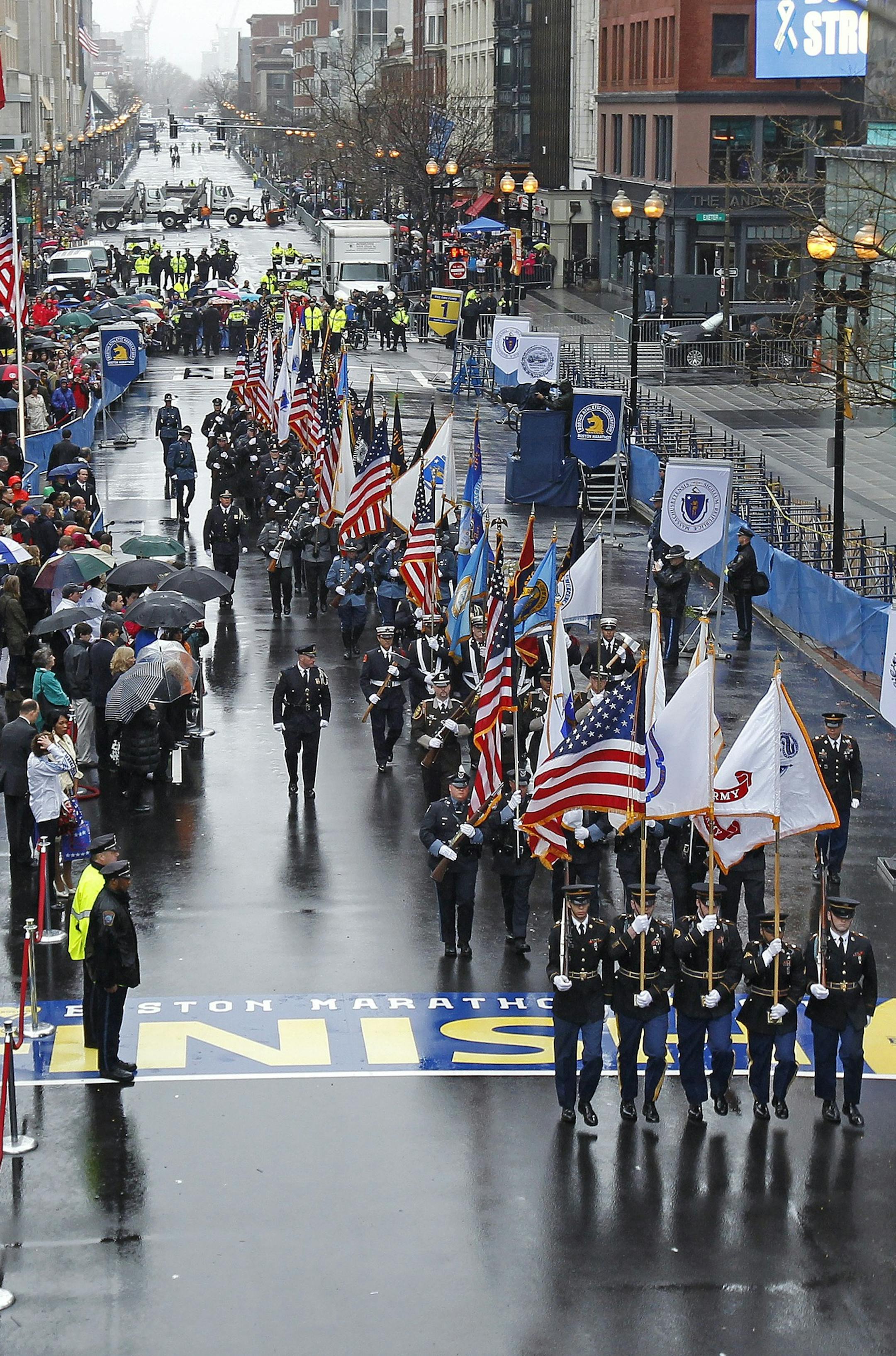 Color guards cross the finish line following a tribute in honor of the one year anniversary of the Boston Marathon bombings, Tuesday, April 15, 2014 in Boston. (AP Photo/Charles Krupa)