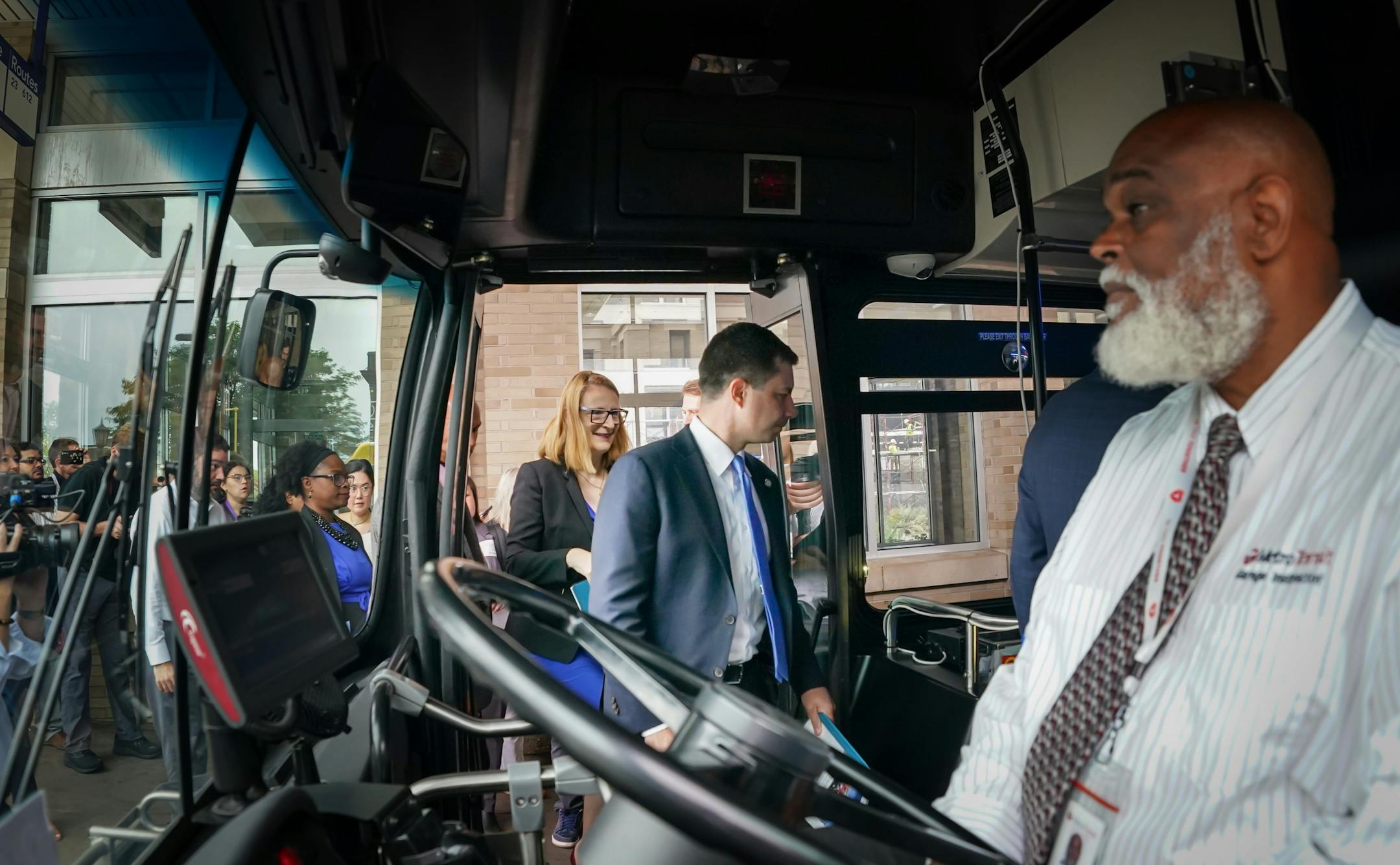 U.S. Transportation Secretary Pete Buttigieg boarded an electric bus for a tour along the coming B Line Thursday, Aug. 25, 2022, Minneapolis, Minn. 32-year driver Duane Moore, right, drove them on the tour. U.S. Transportation Secretary Pete Buttigieg, on a four-day tour of six states to highlight infrastructure projects funded with federal dollars in the Biden administration's infrastructure act, will stop in Minneapolis to talk about a $12 million grant to support Bus Rapid Transit on the Lake Street Corridor with new turn lanes, bus only lanes, and ADA upgrades.