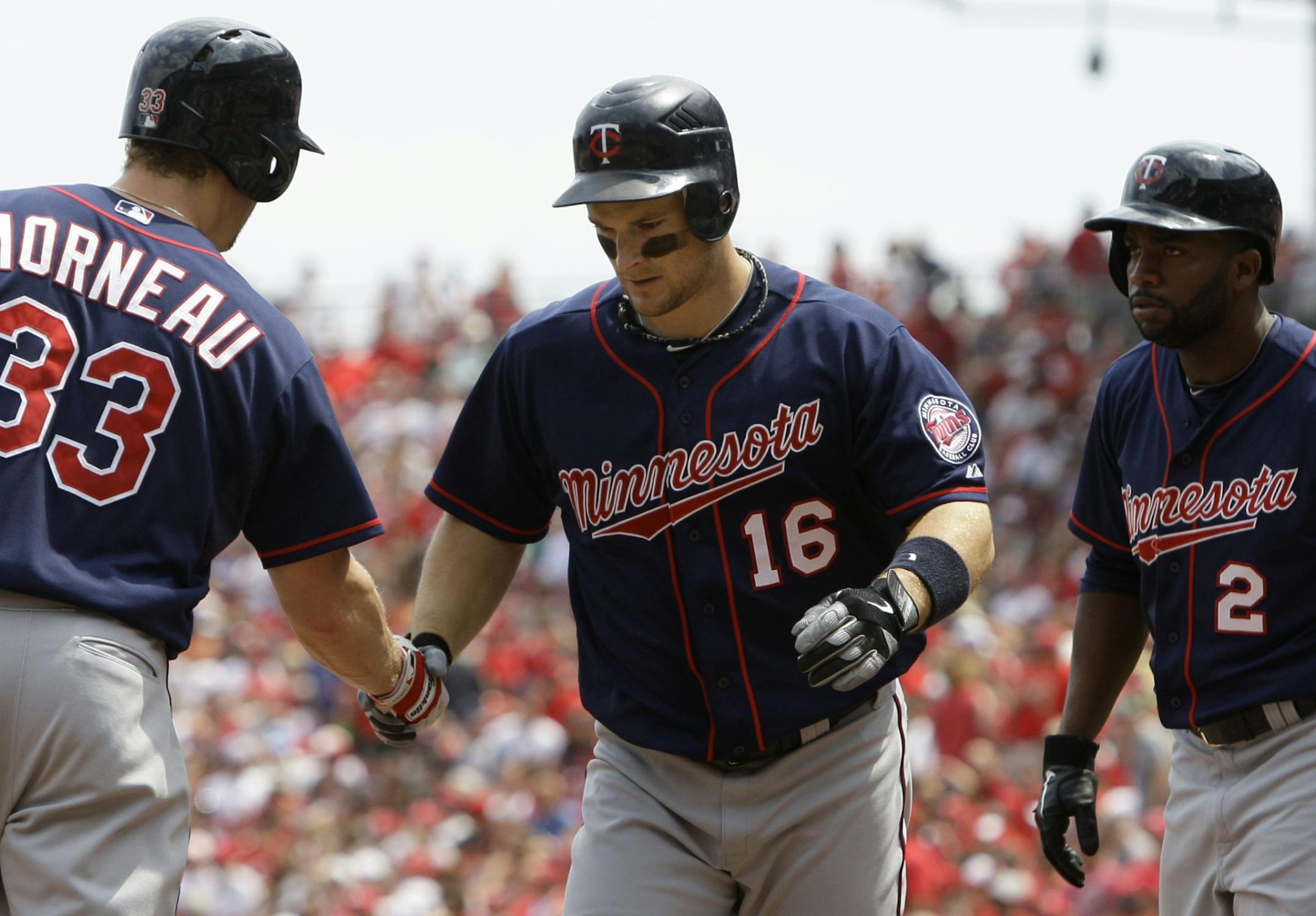 Minnesota Twins' Josh Willingham (16) is congratulated by Justin Morneau (33) after Willingham drove in Denard Span (2) with a home run off Cincinnati Reds relief pitcher Aroldis Chapman in the ninth inning of a baseball game on Sunday, June 24, 2012 in Cincinnati. Minnesota won 4-3.
