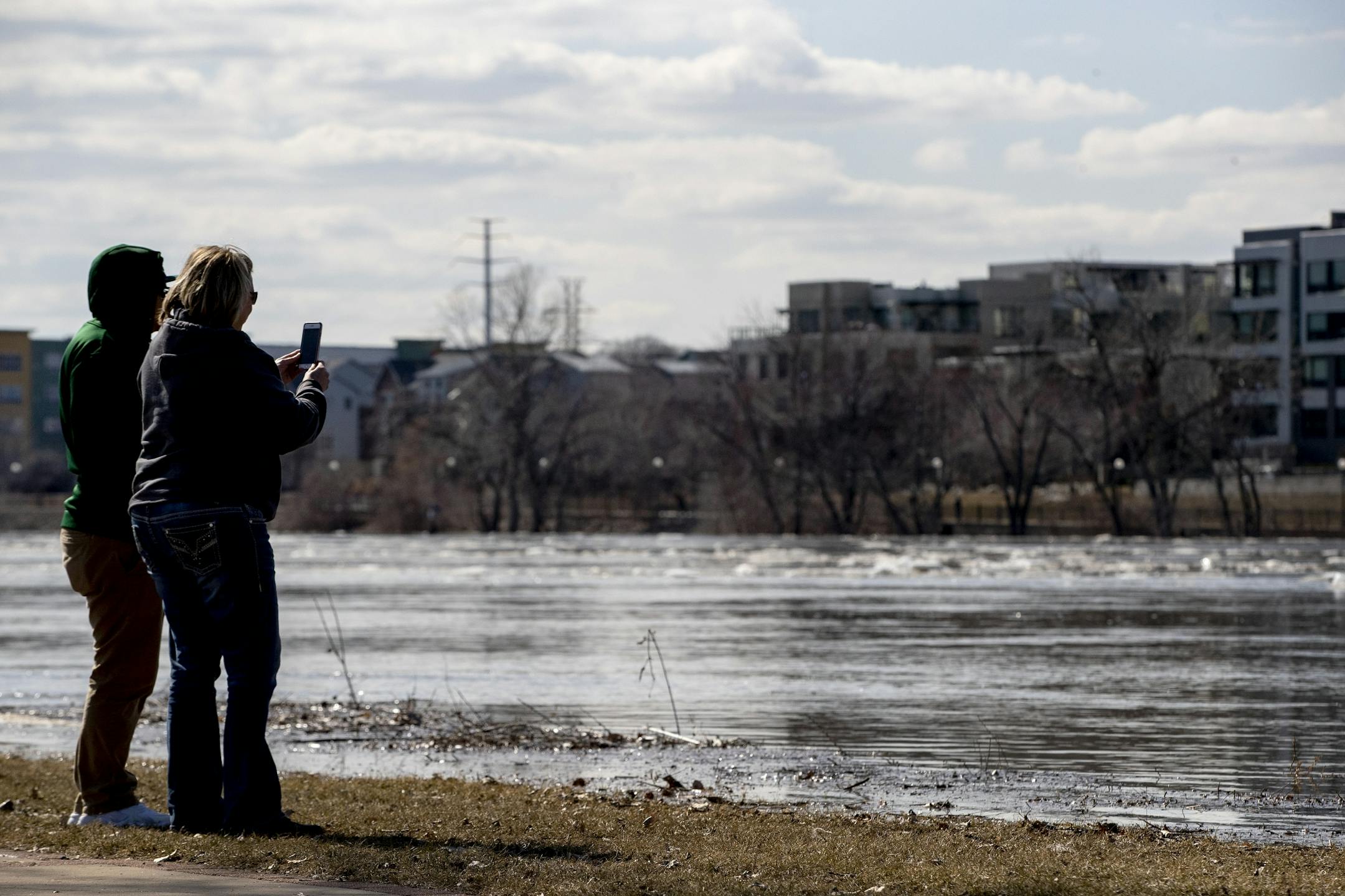 Pedestrians came out to view the flooding at Harriet Island Regional Park and the flowing Mississippi river on Monday afternoon.