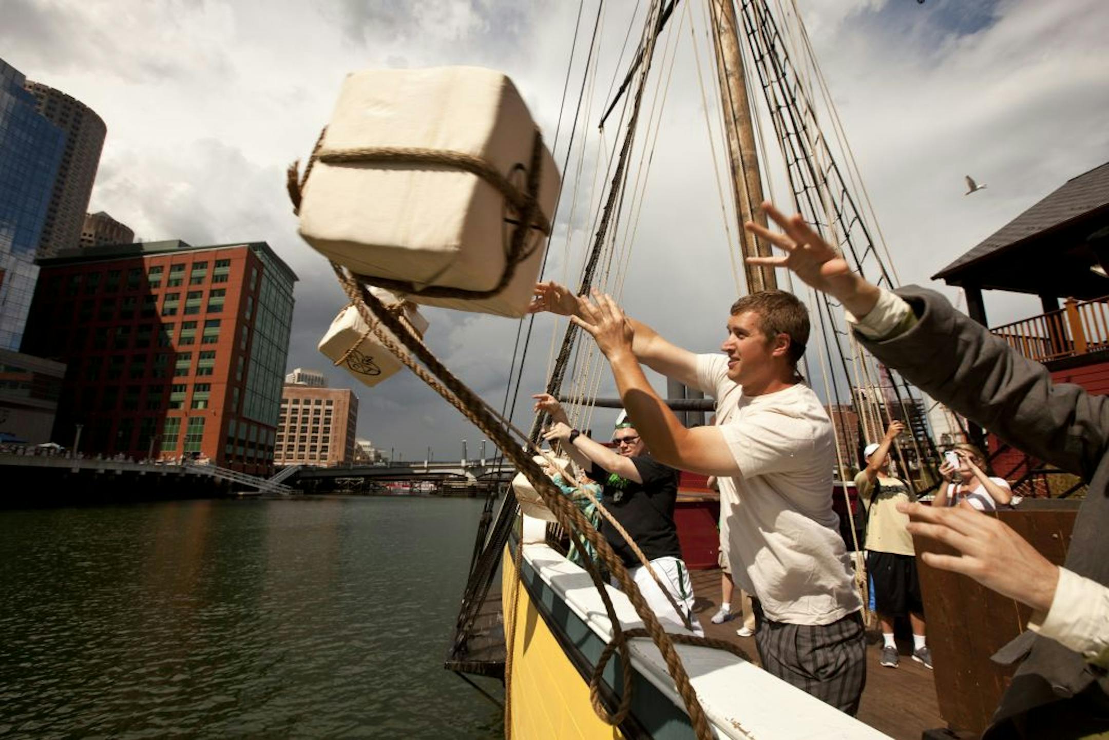 Museum goer Will Swan throws a replica tea chest overboard from the Beaver at the recently renovated Boston Tea Party Ships and Museum in Boston.
