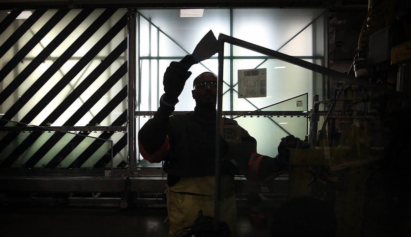 A worker from Apogee subsidiary Viracon prepared a panel of glass in 2015 for use in the U.S. Bank Stadium. (JIM GEHRZ/Star Tribune)