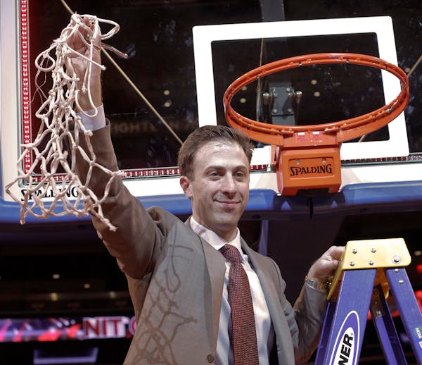 Minnesota coach Richard Pitino holds up the net after Minnesota defeated SMU 65-63 in an NCAA college basketball game in the final of the NIT, Thursda