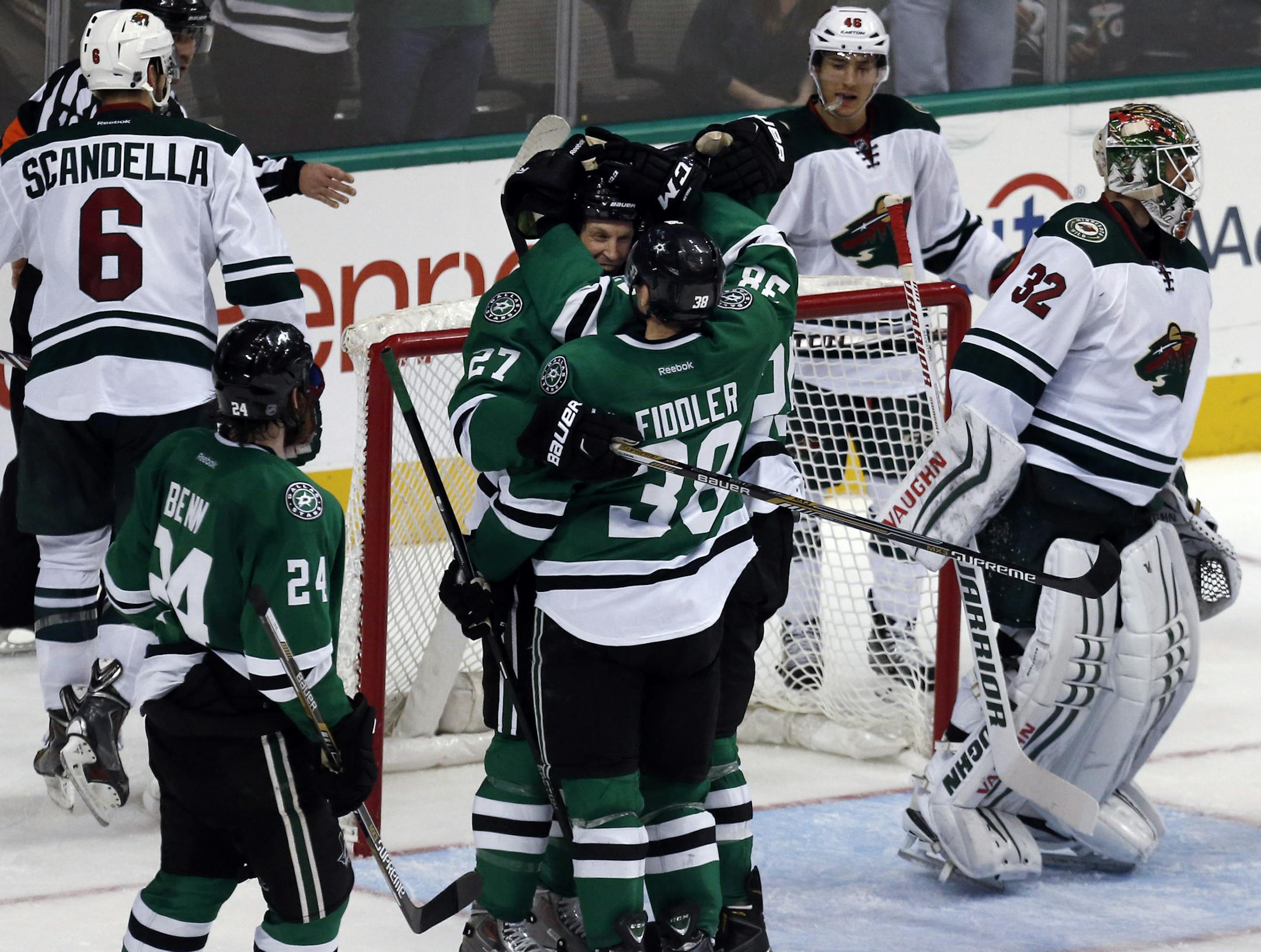 Dallas Stars left wing Travis Moen (27), center Vernon Fiddler (38) and right wing Brett Ritchie, right, hug after Moen's goal during the third period of an NHL hockey game against the Minnesota Wild on Saturday, Jan. 3, 2015, in Dallas. The Stars won 7-1. (AP Photo/John F. Rhodes)